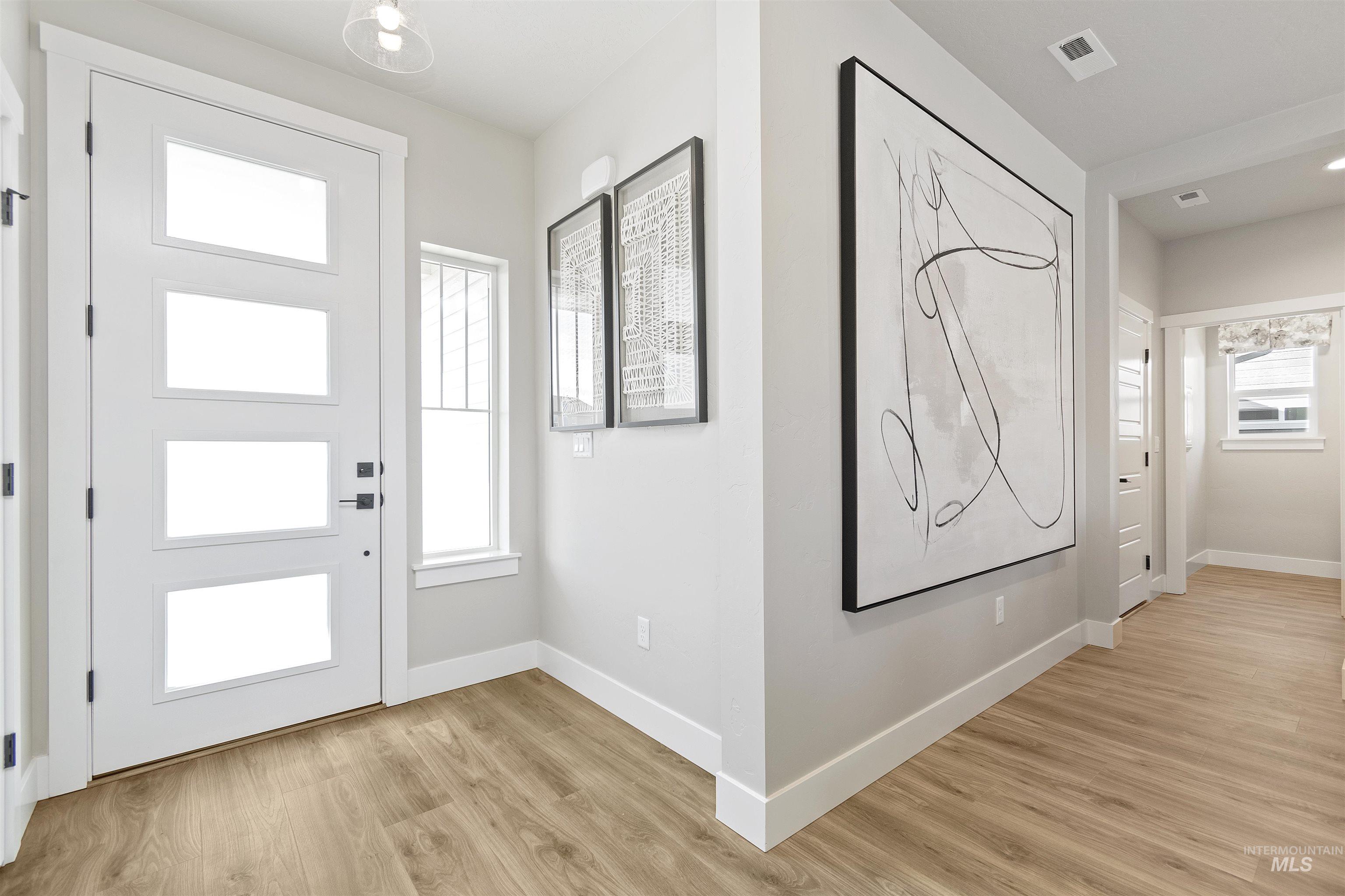 Foyer entrance with baseboards and light wood-style flooring