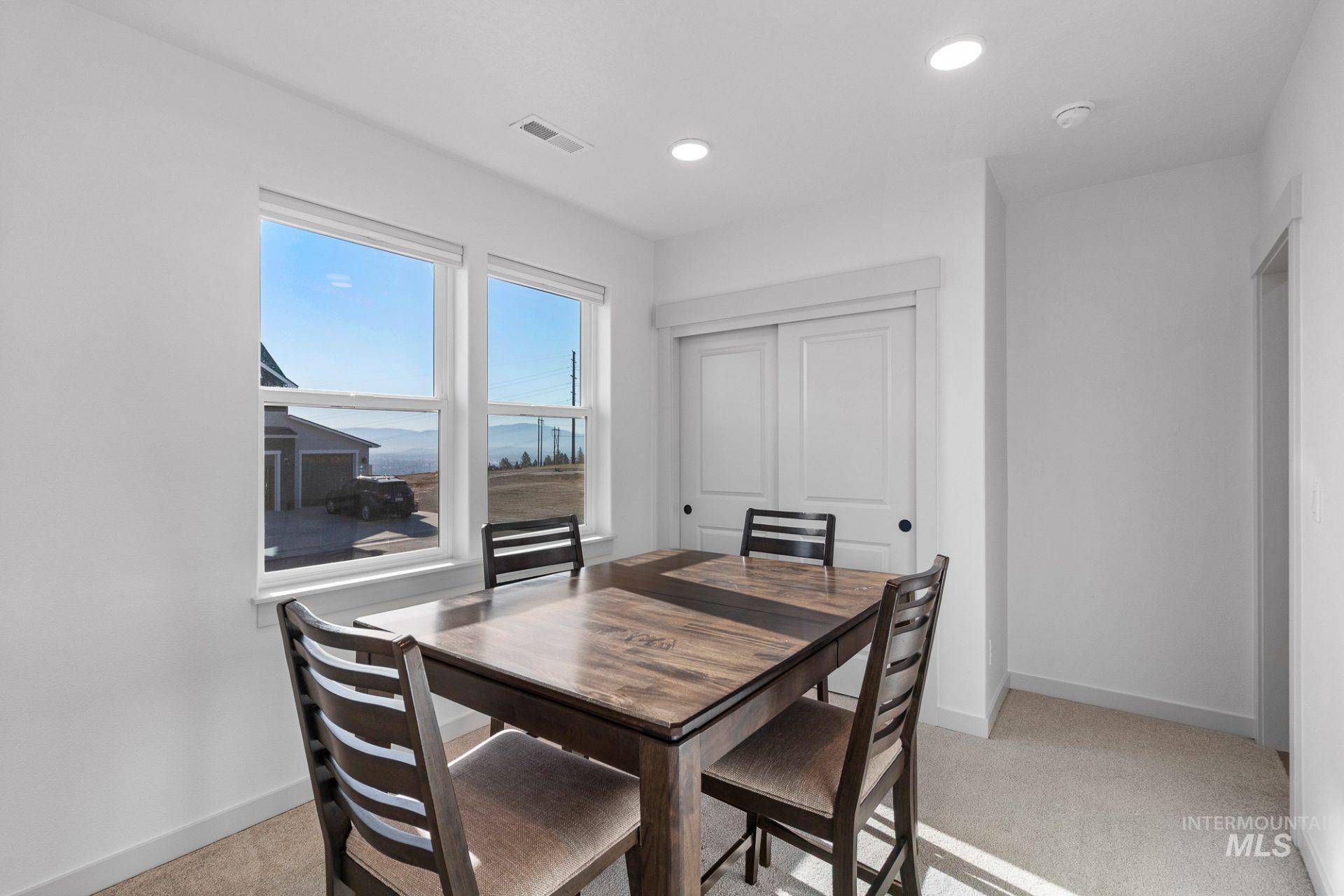 Dining space featuring light colored carpet and recessed lighting