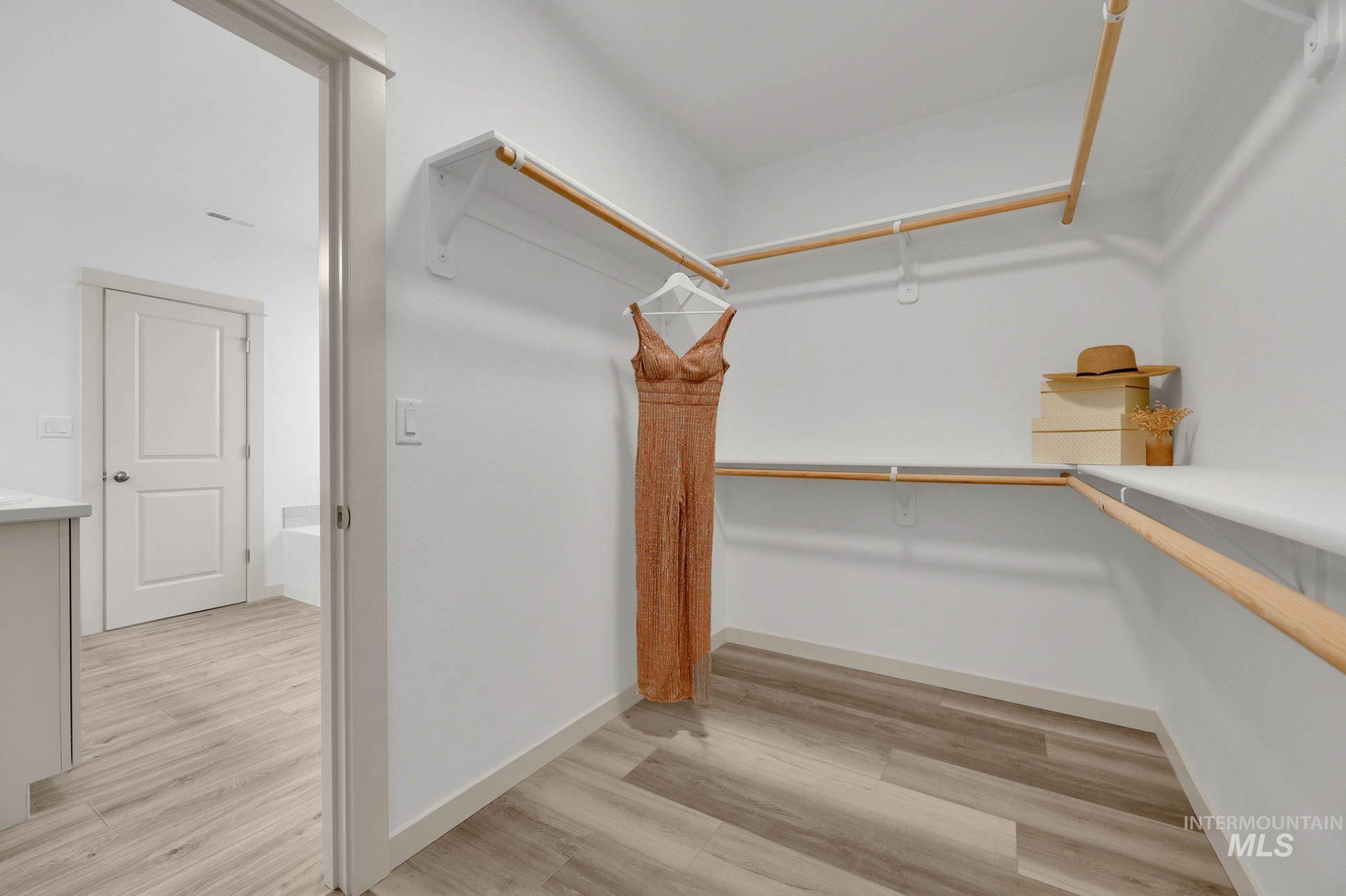 Spacious closet featuring light wood-style flooring