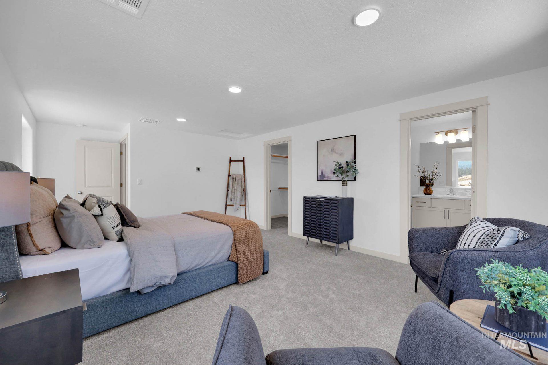 Carpeted bedroom featuring a walk in closet, recessed lighting, and ensuite bathroom