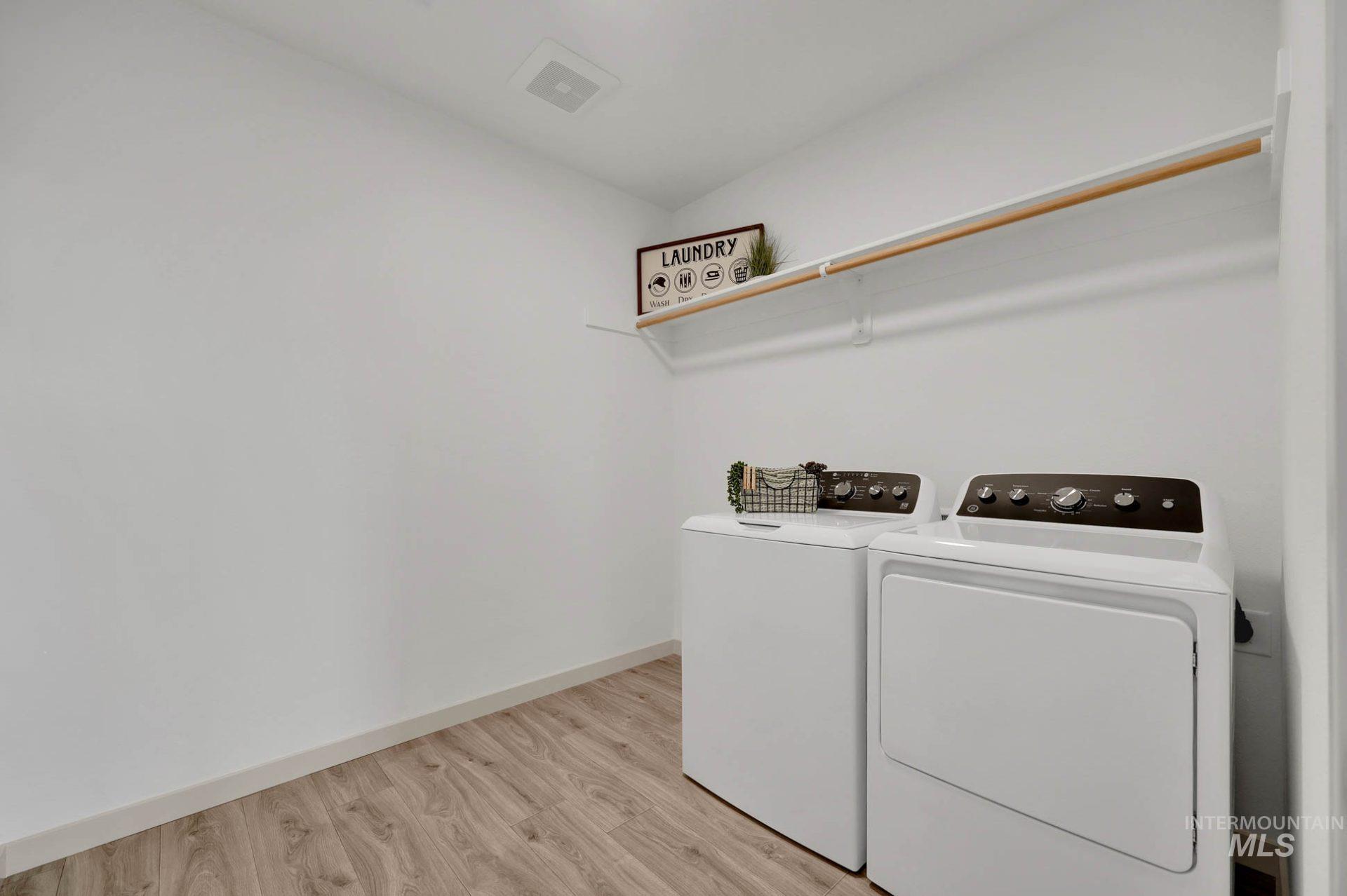 Laundry area featuring light wood-style flooring and washer and dryer