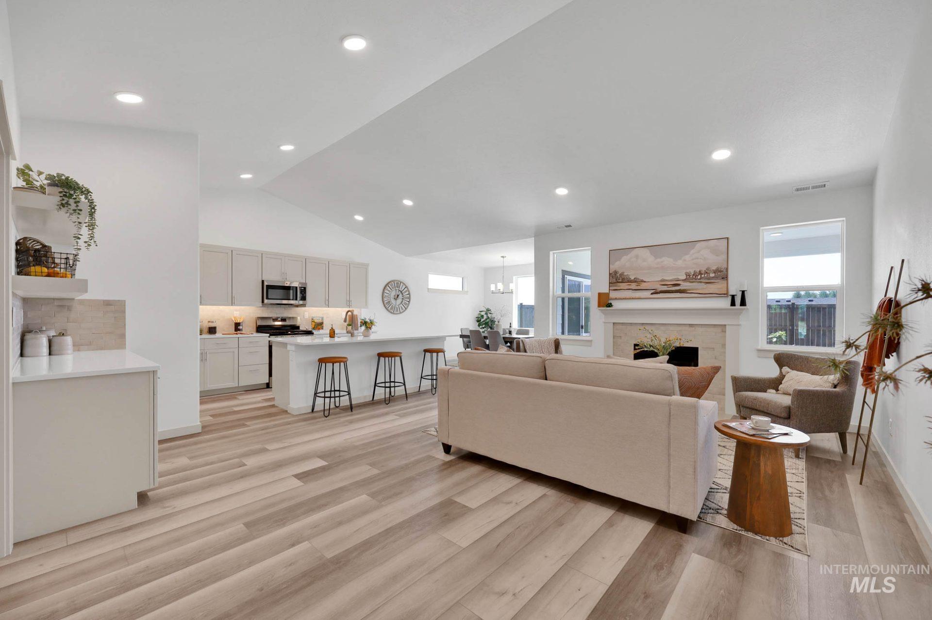 Living area with healthy amount of natural light, lofted ceiling, light wood-type flooring, recessed lighting, and a fireplace