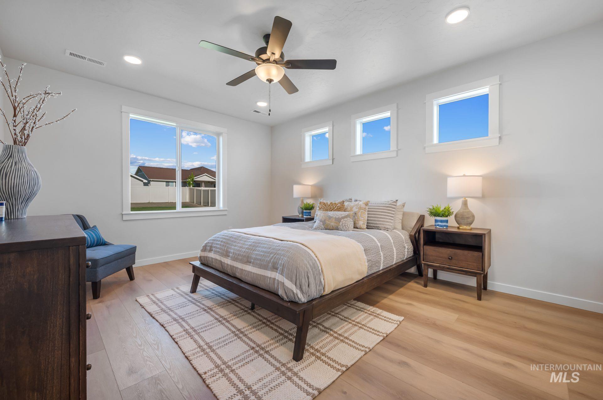 Bedroom with light wood-style floors, a ceiling fan, and recessed lighting