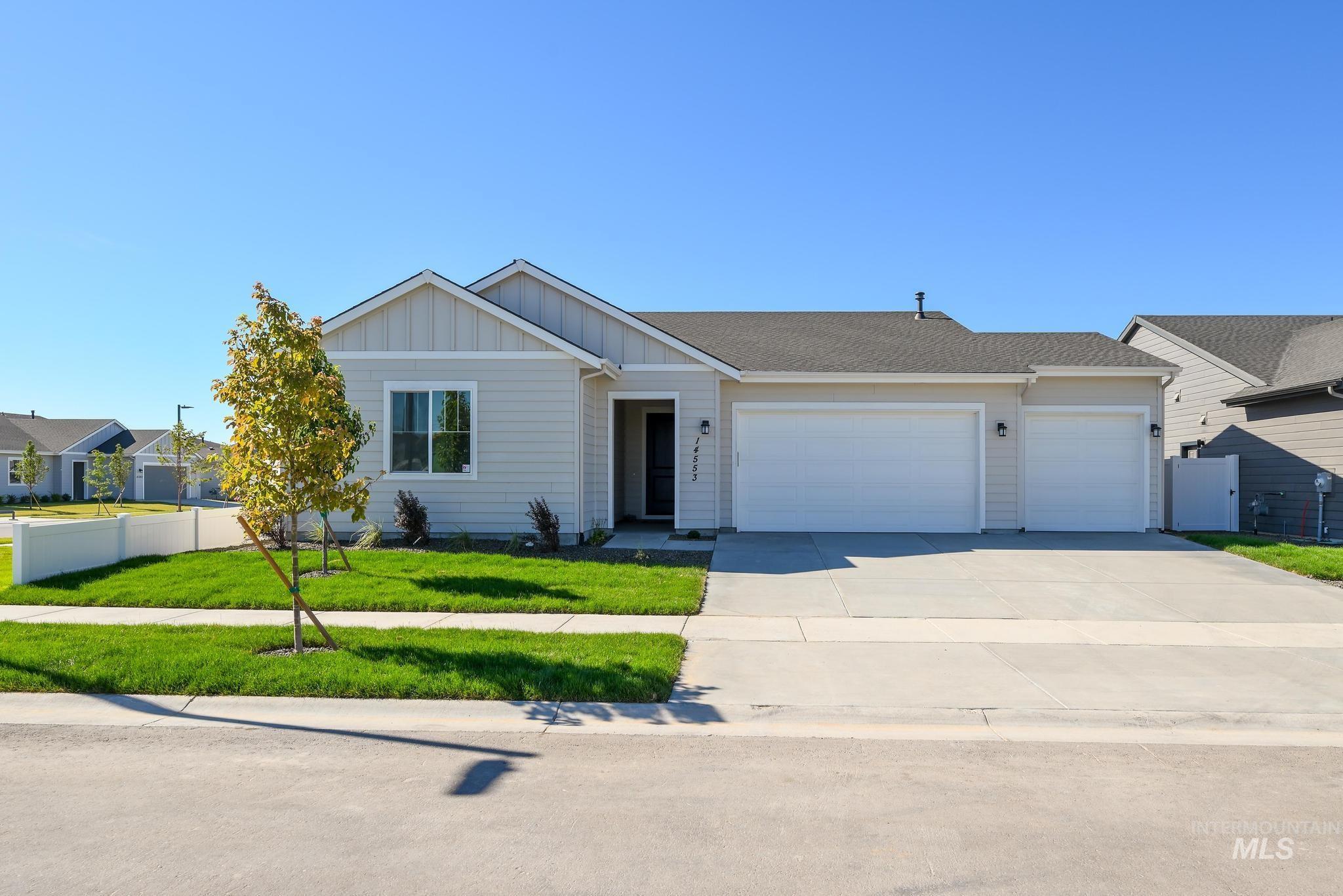 Ranch-style house featuring board and batten siding, an attached garage, concrete driveway, and roof with shingles