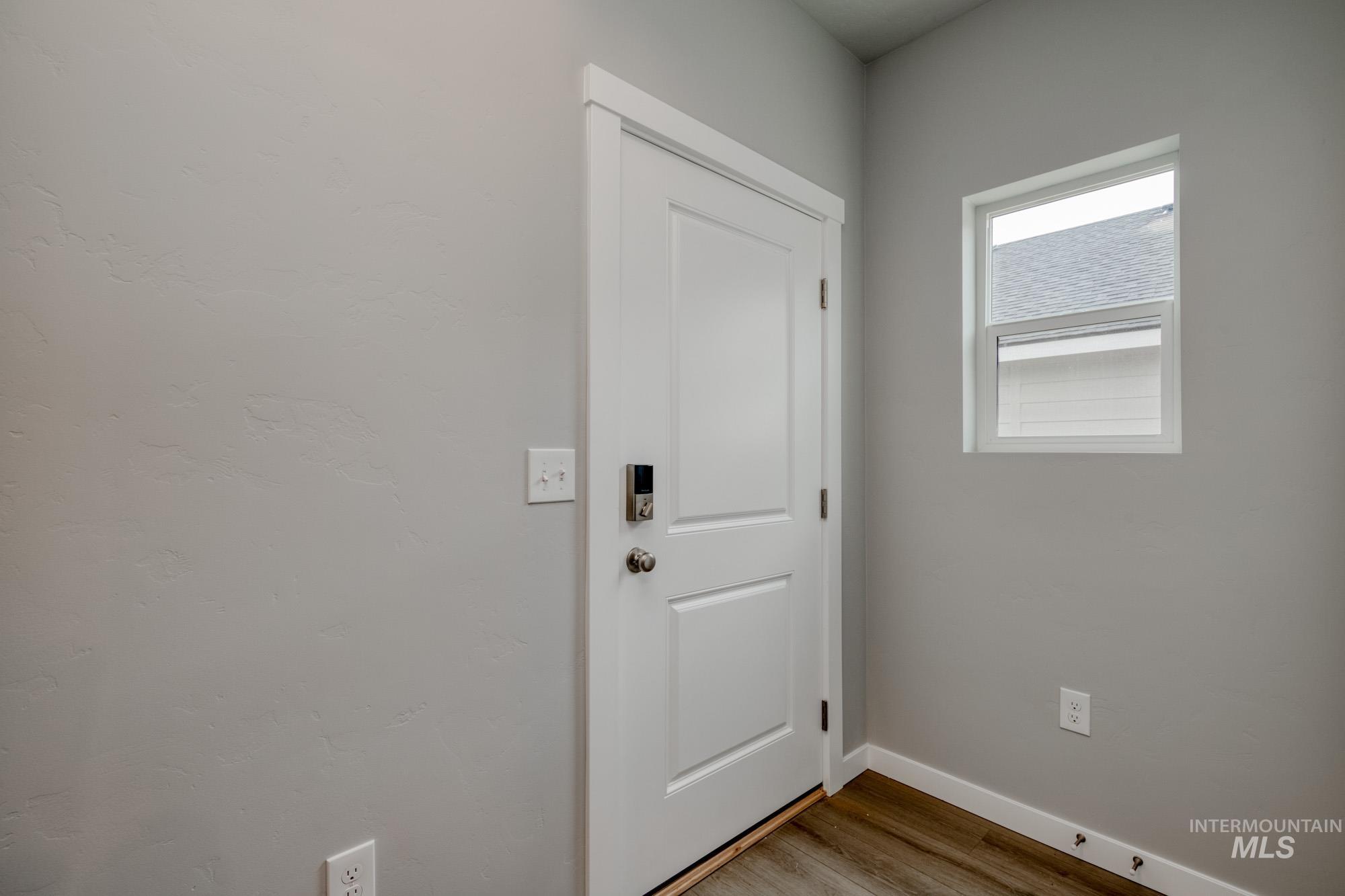 Doorway with wood finished floors and baseboards
