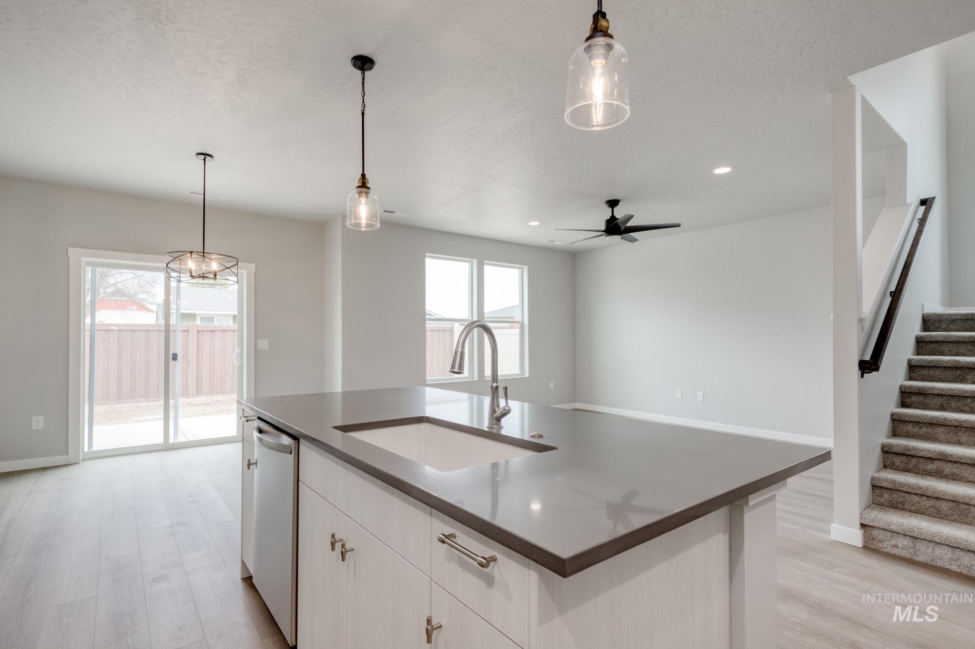 Kitchen with light wood-style flooring, hanging light fixtures, white cabinetry, recessed lighting, and a textured ceiling