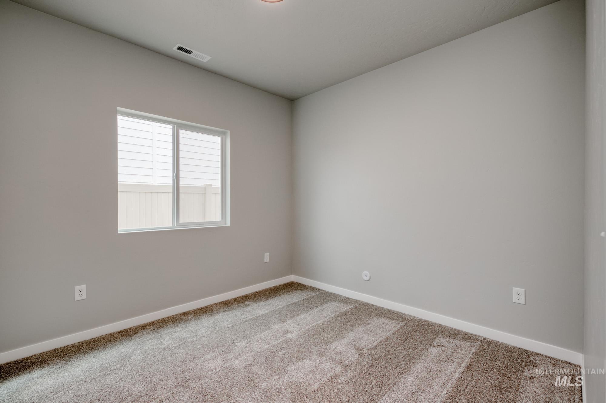 Carpeted spare room with baseboards