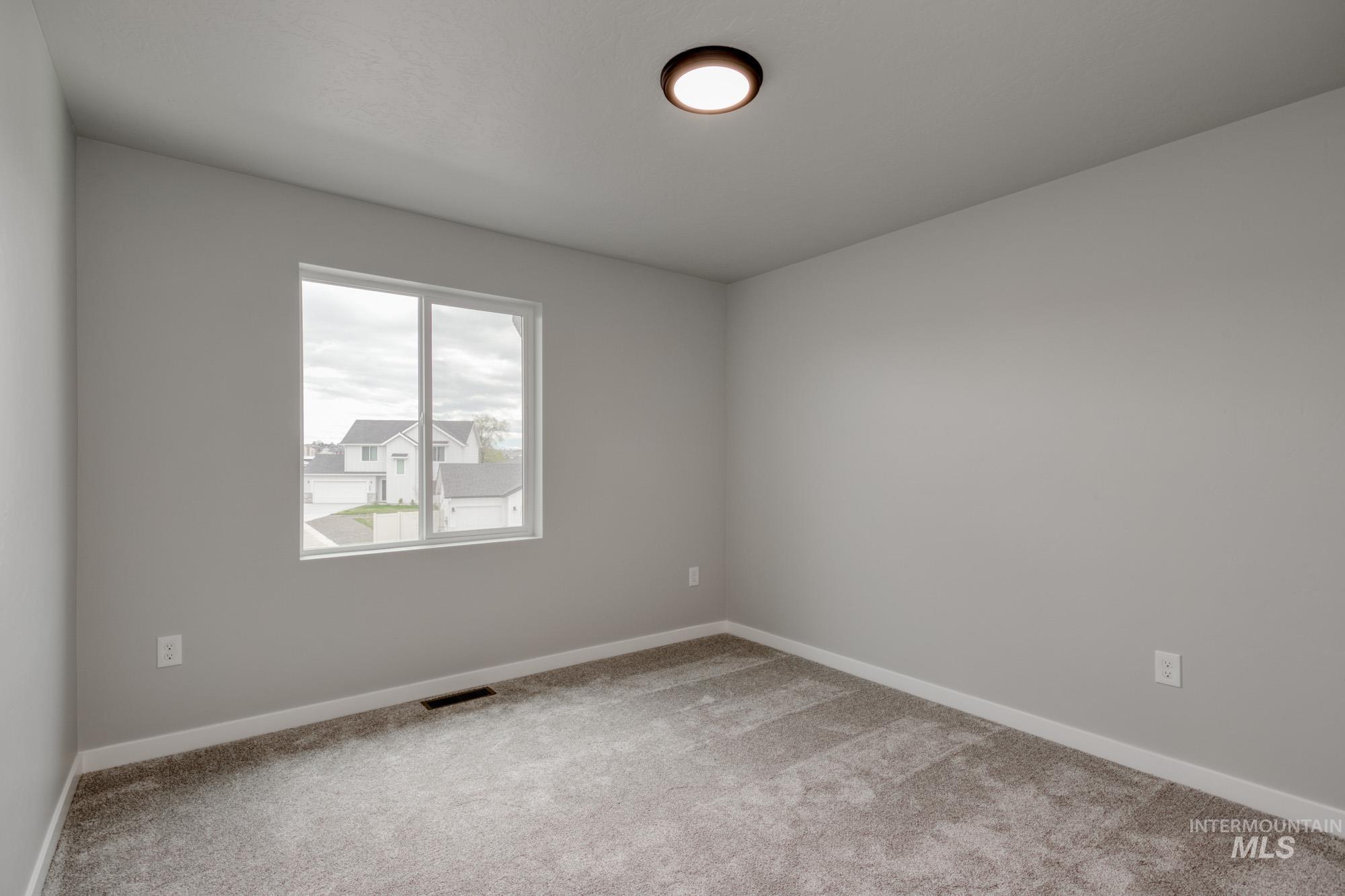 Empty room featuring light carpet and baseboards
