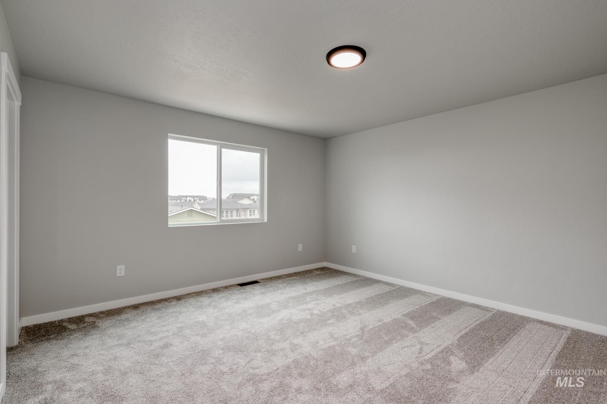 Empty room featuring baseboards and light colored carpet