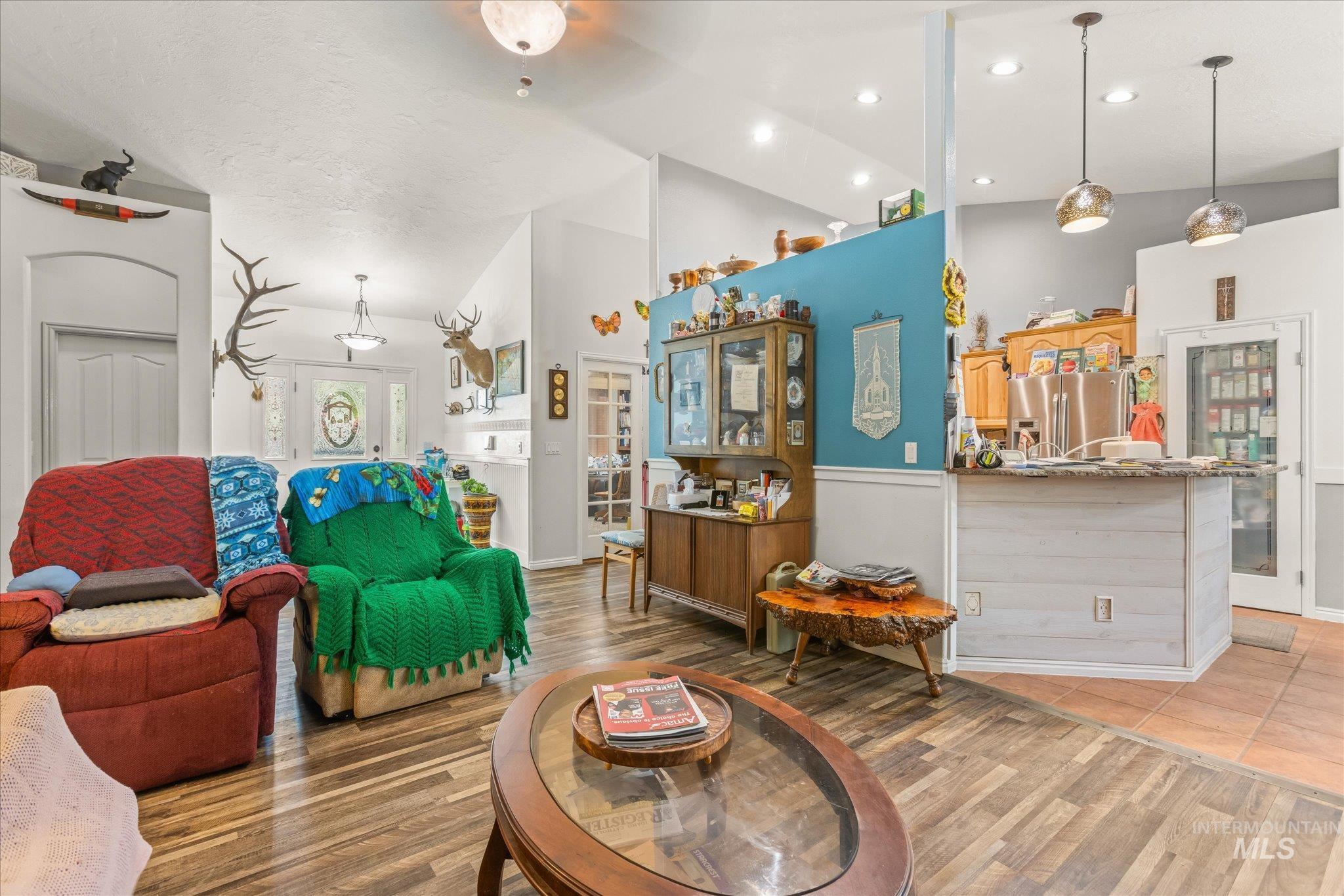 Living room with high vaulted ceiling, light wood-style flooring, and recessed lighting