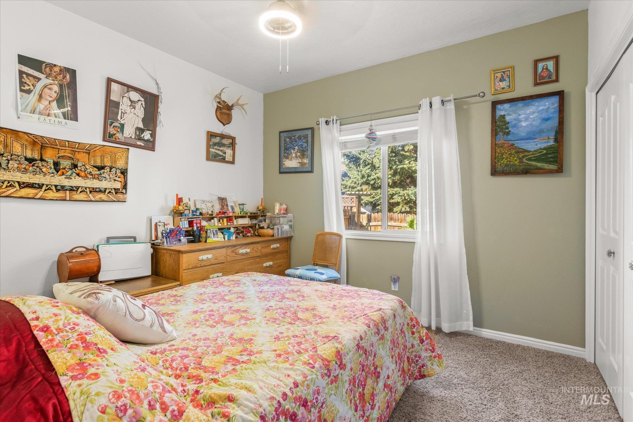 Bedroom featuring light colored carpet, a closet, and a ceiling fan