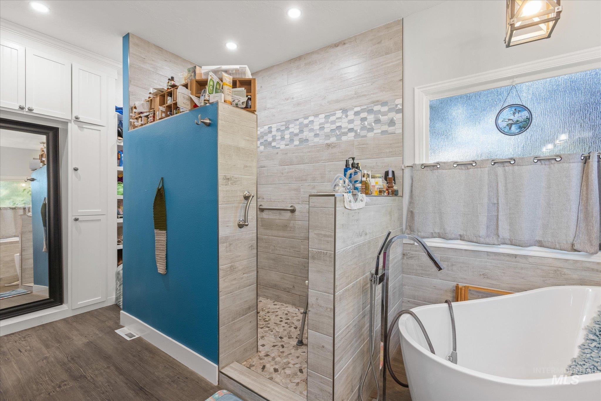 Full bathroom featuring a freestanding bath, a walk in shower, wood finished floors, pet washing station, and recessed lighting
