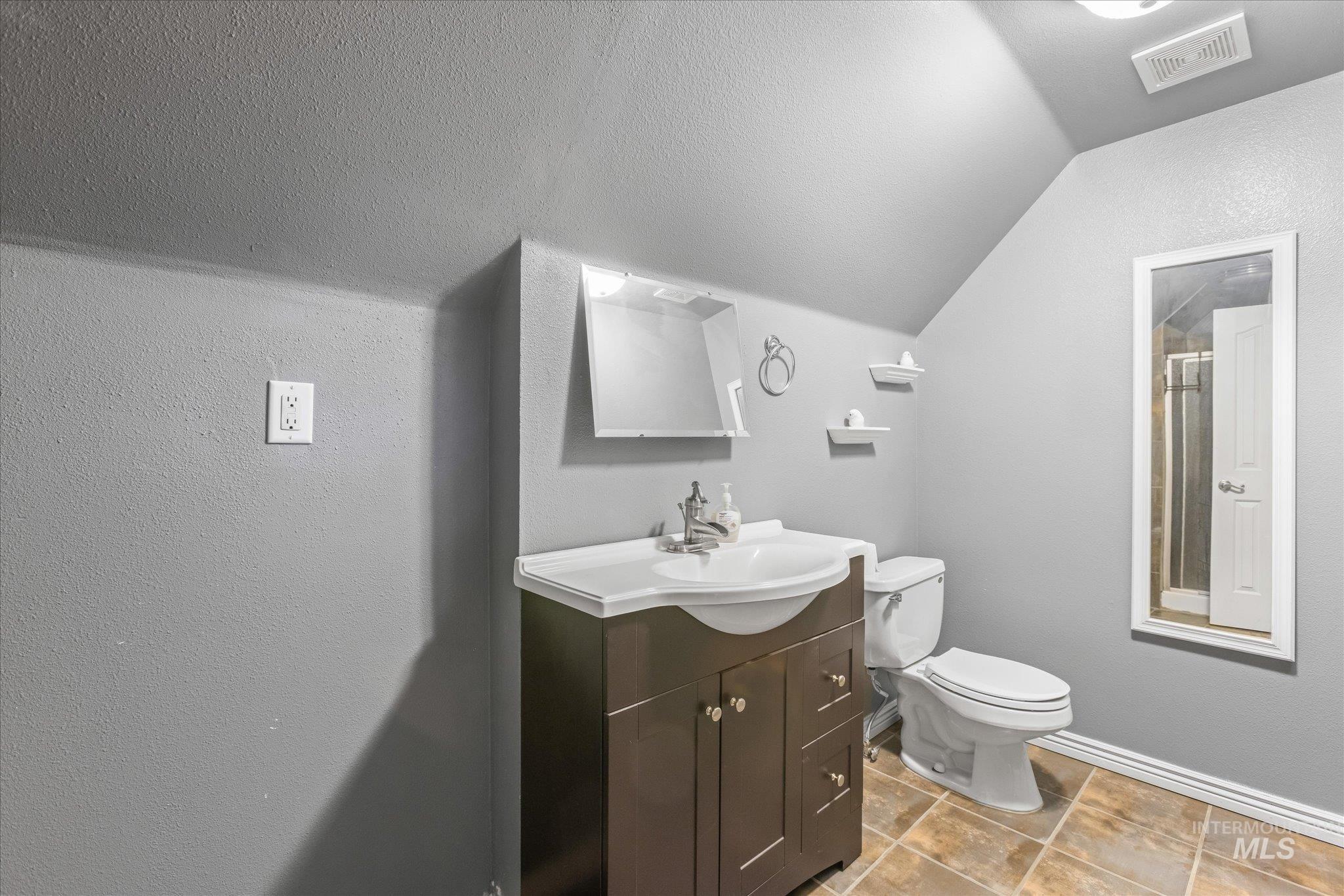 Bathroom featuring vanity and a textured wall