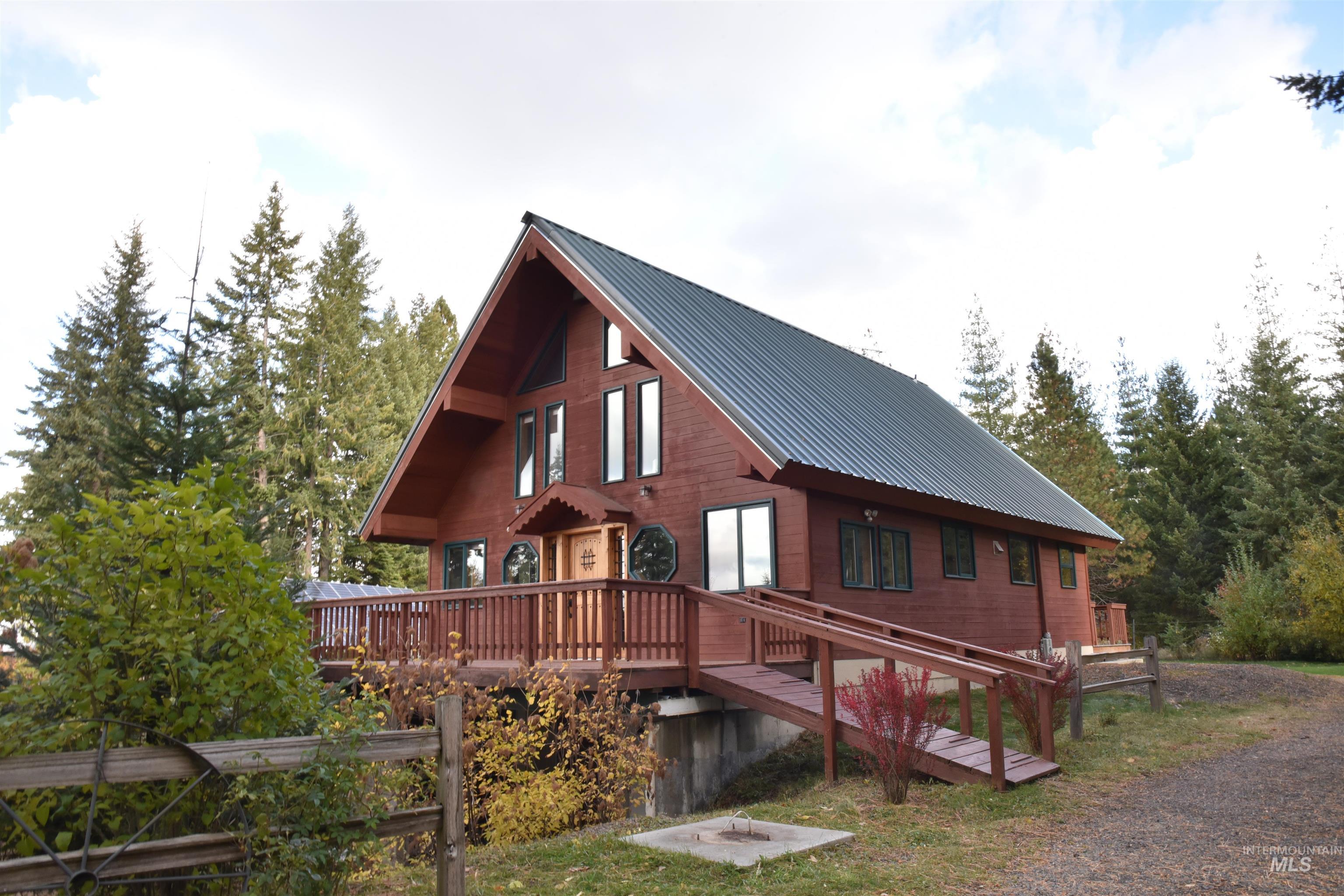 View of side of property featuring a metal roof and a wooden deck