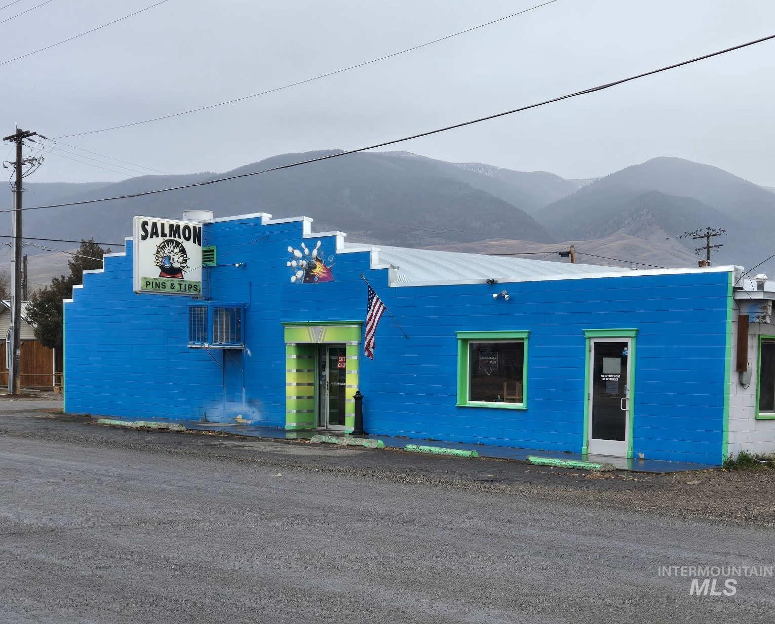 View of front of home featuring a mountain view and an AC wall unit
