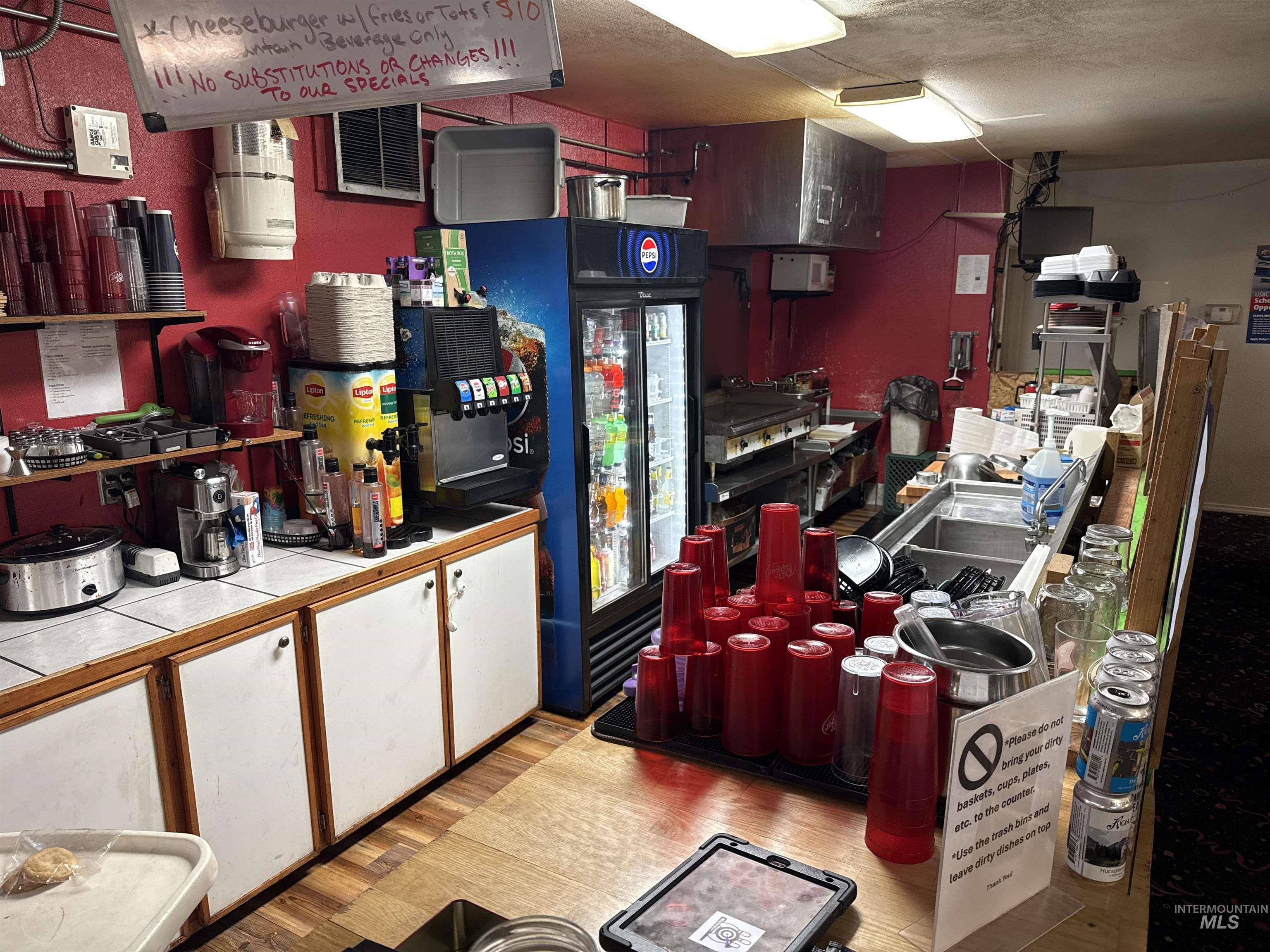 Kitchen with white cabinetry, a textured ceiling, and tile counters