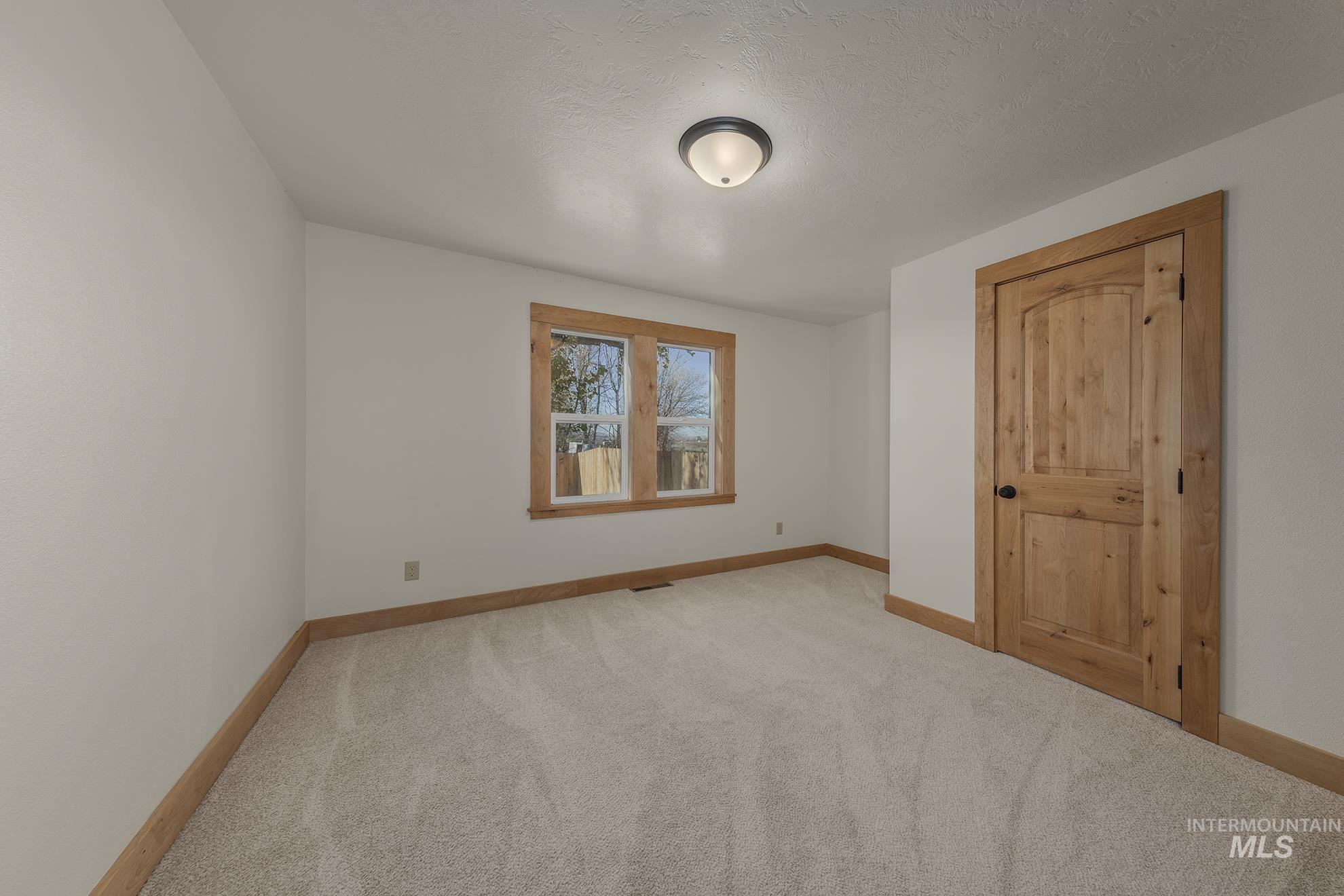 Unfurnished bedroom featuring carpet and a textured ceiling