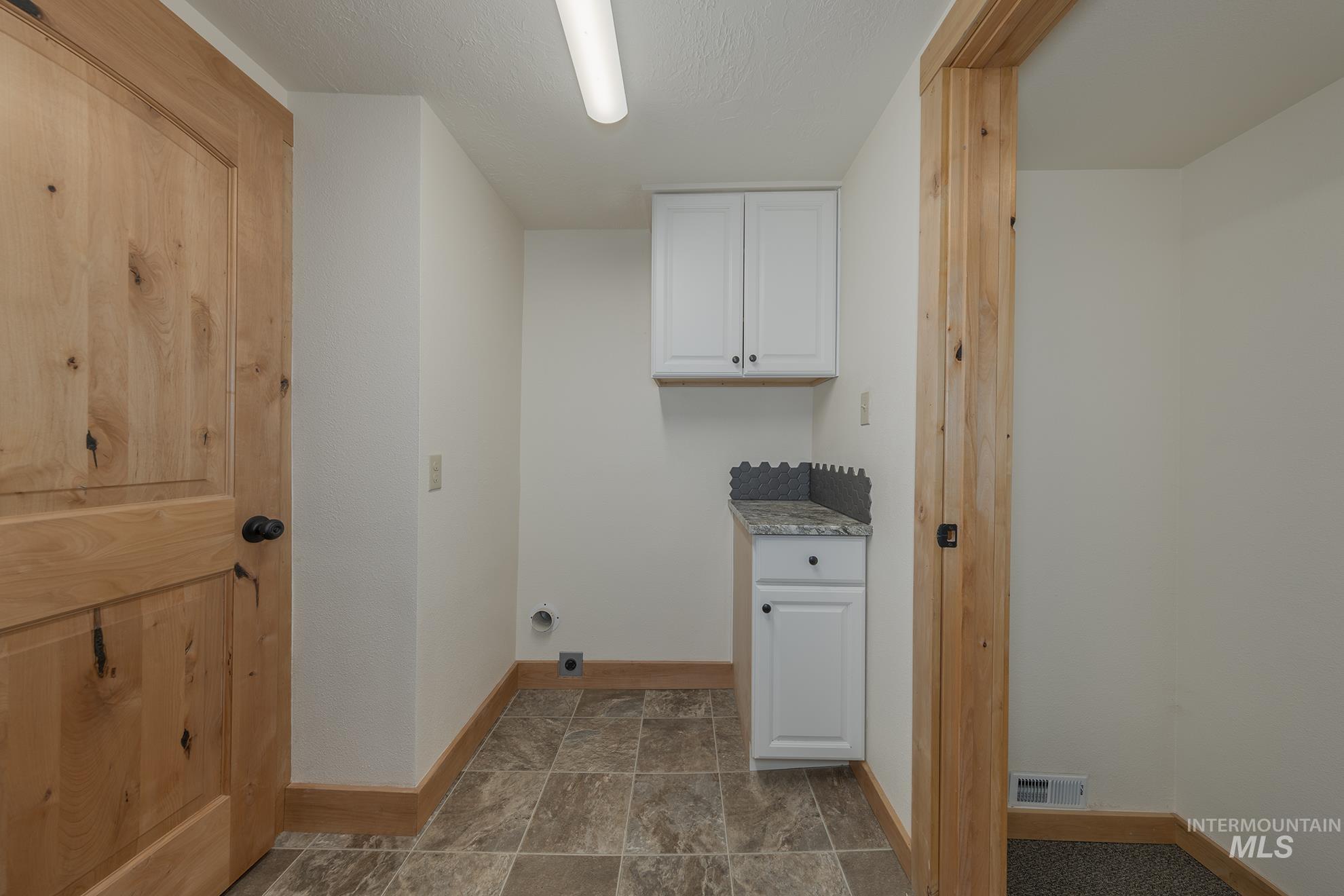 Laundry room with baseboards and cabinet space