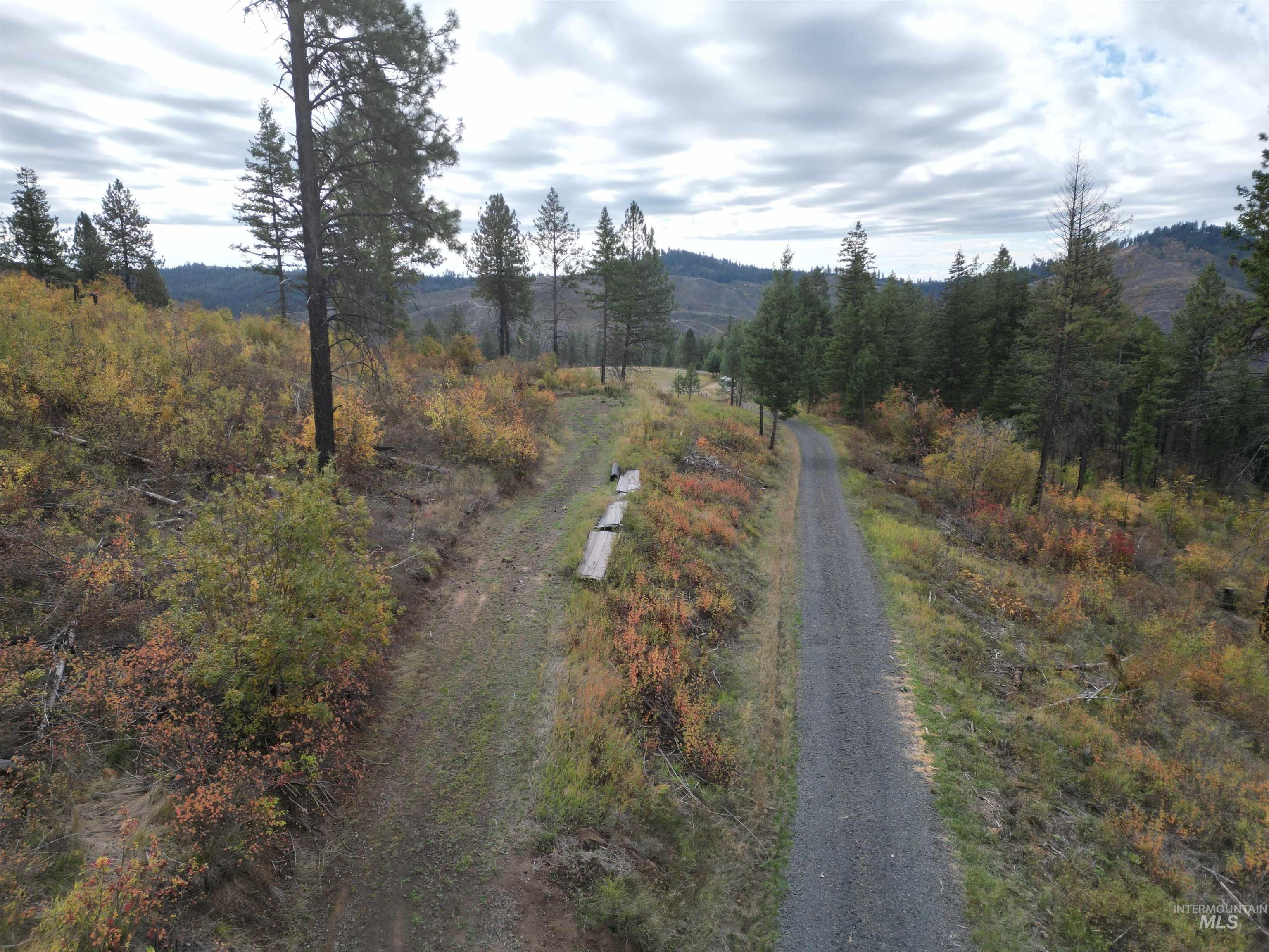 View of dirt / gravel road with a view of countryside and a mountain view