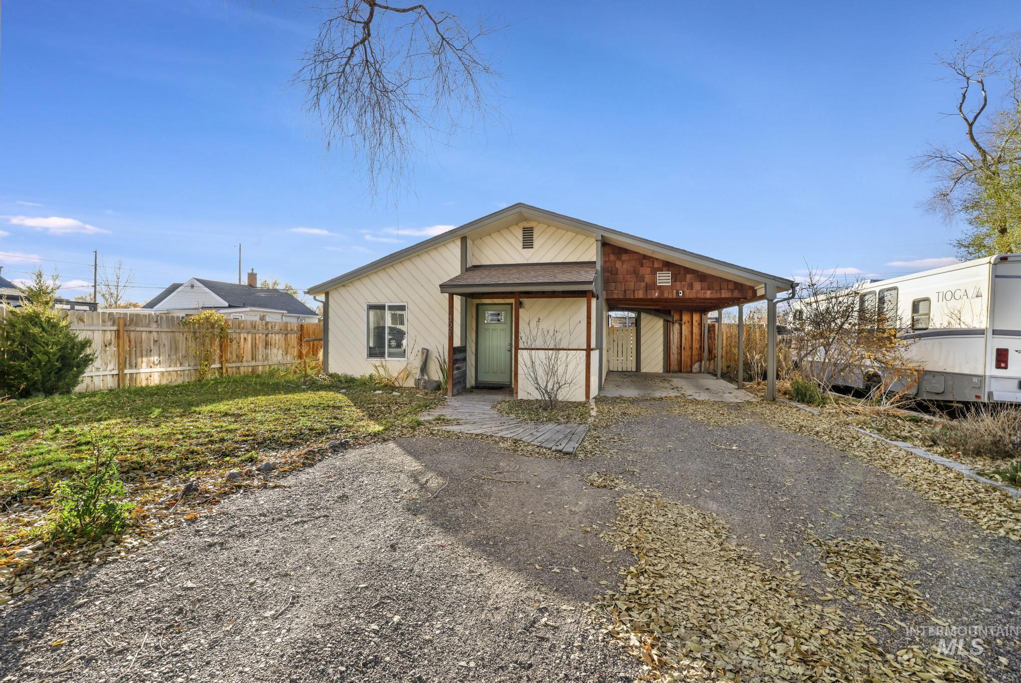 View of front of home featuring driveway, an attached carport, and a porch