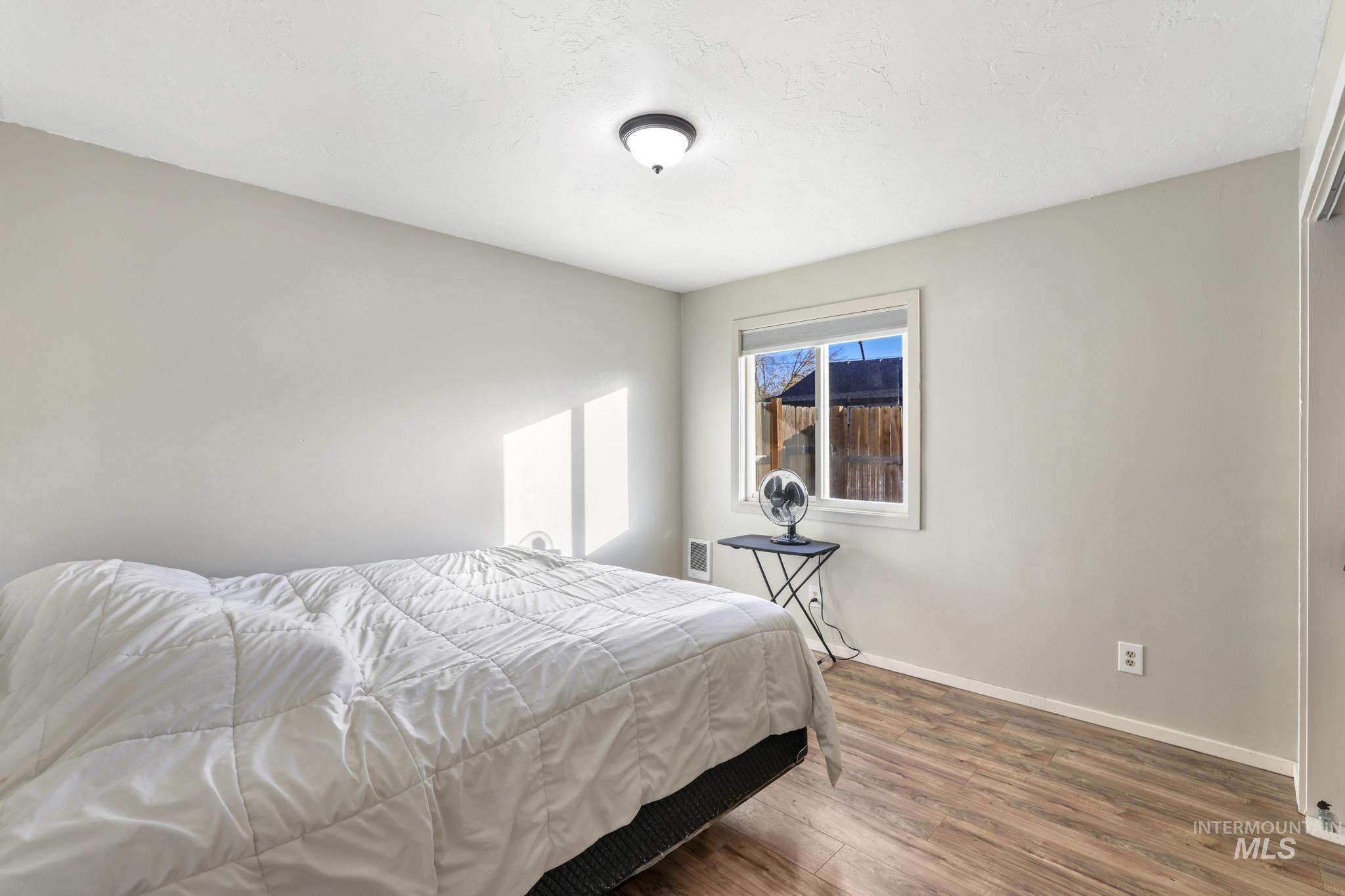 Bedroom featuring wood finished floors and baseboards