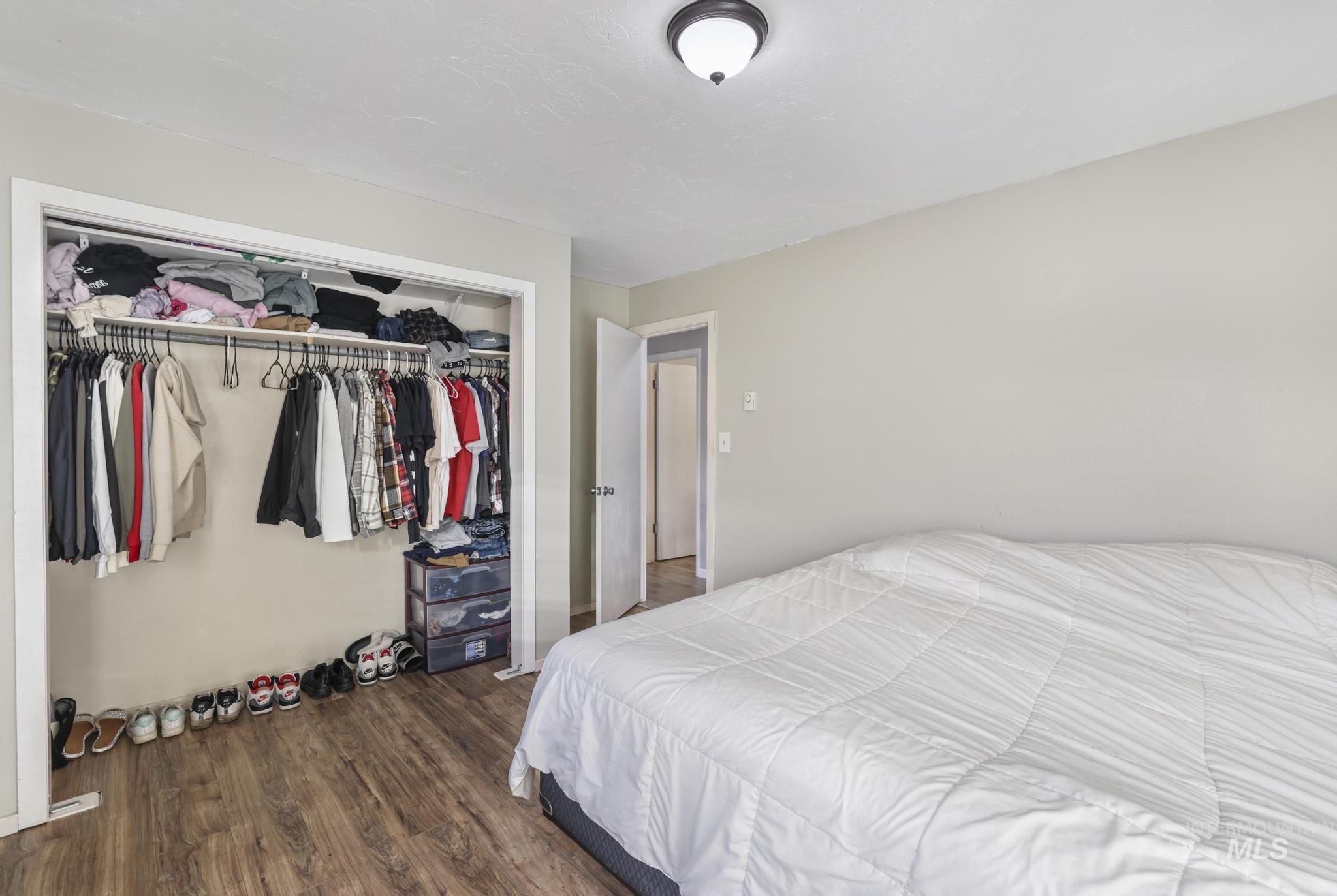 Bedroom featuring dark wood-type flooring and a closet