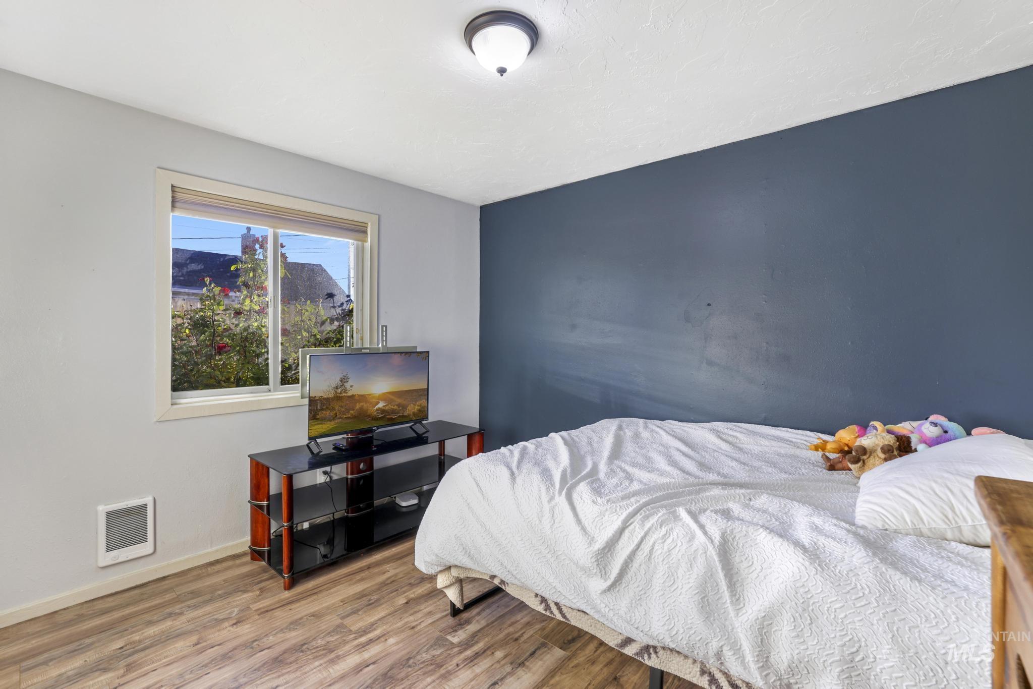 Bedroom with wood finished floors and baseboards