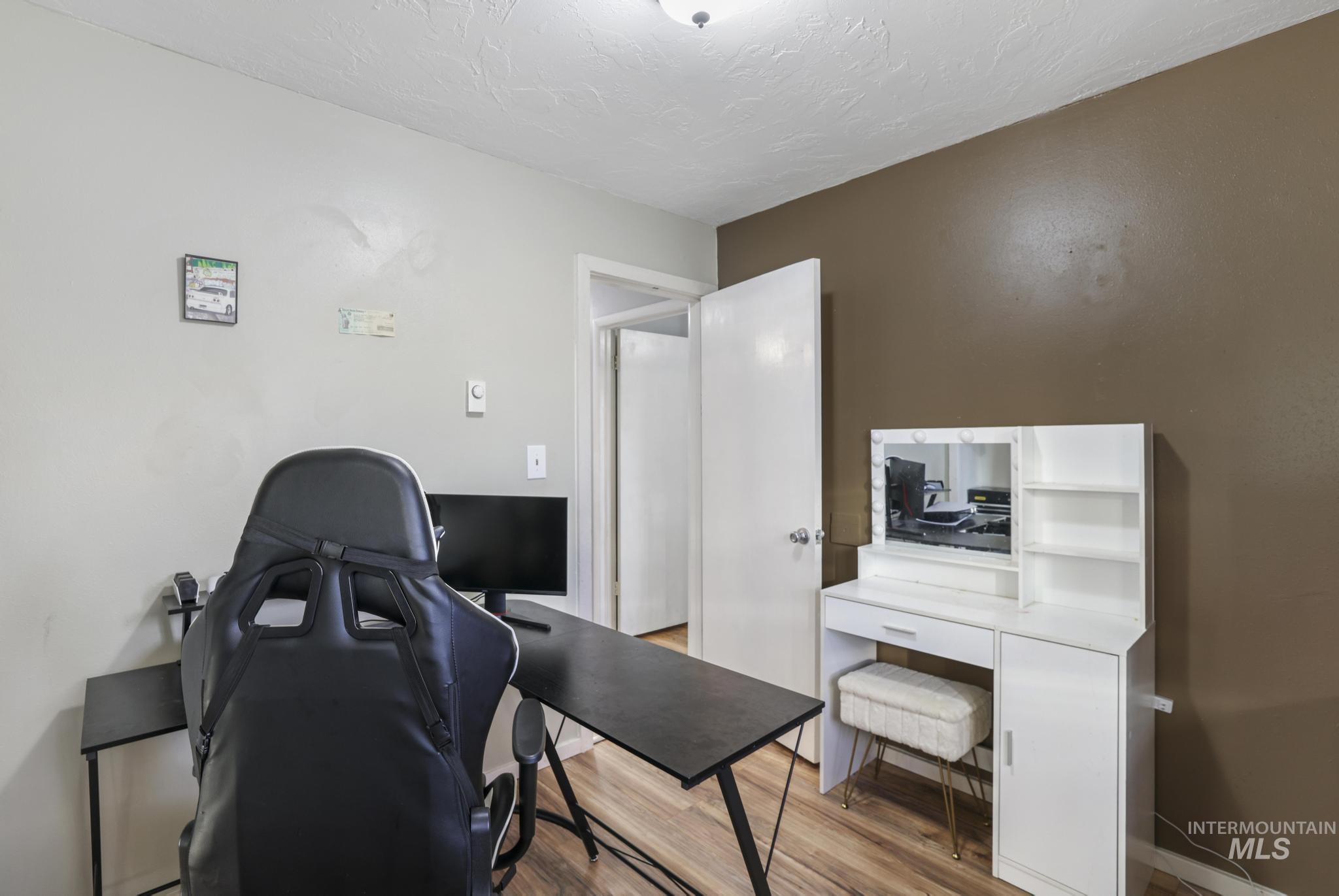Office space with wood finished floors and a textured ceiling