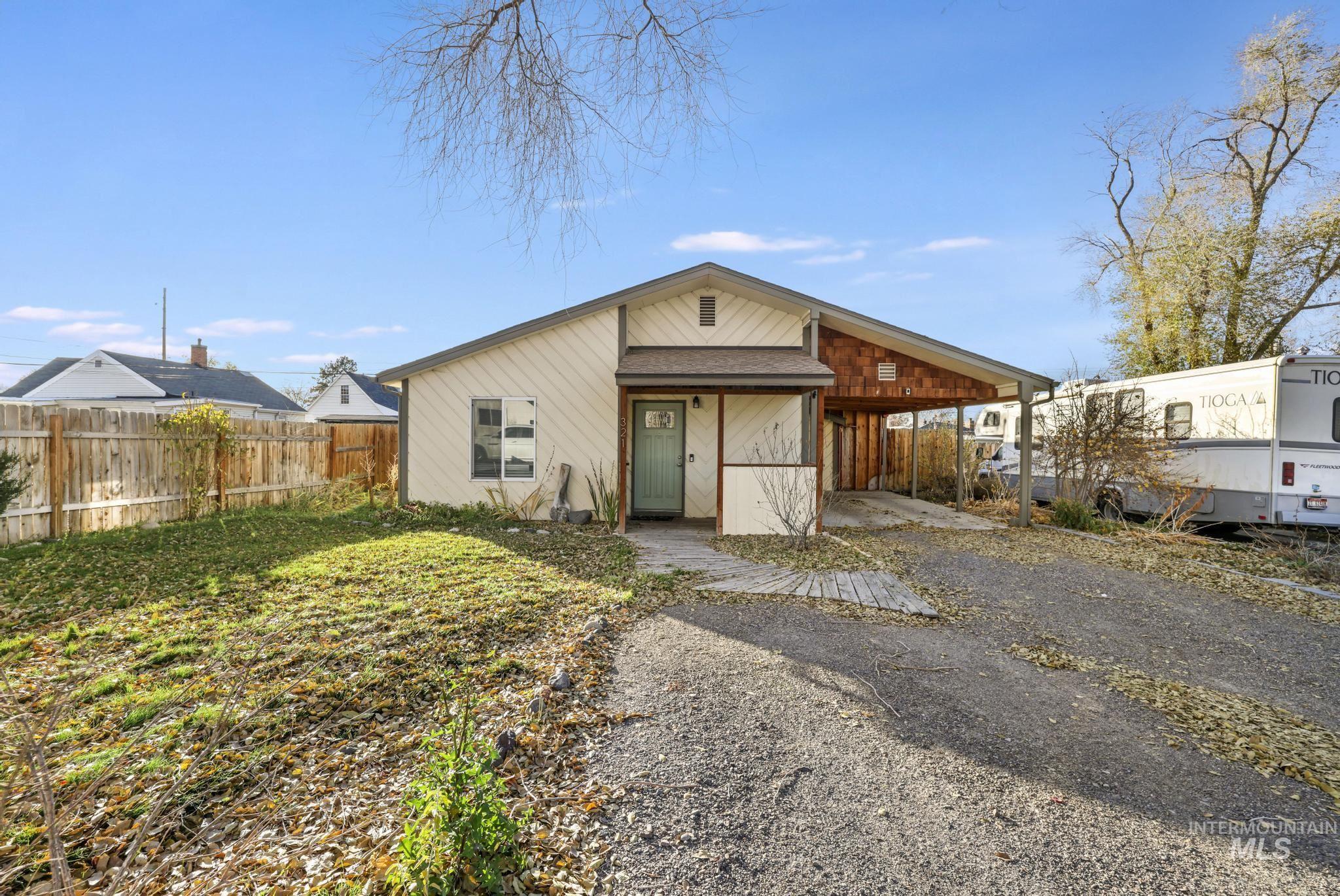 View of front of property with asphalt driveway and an attached carport