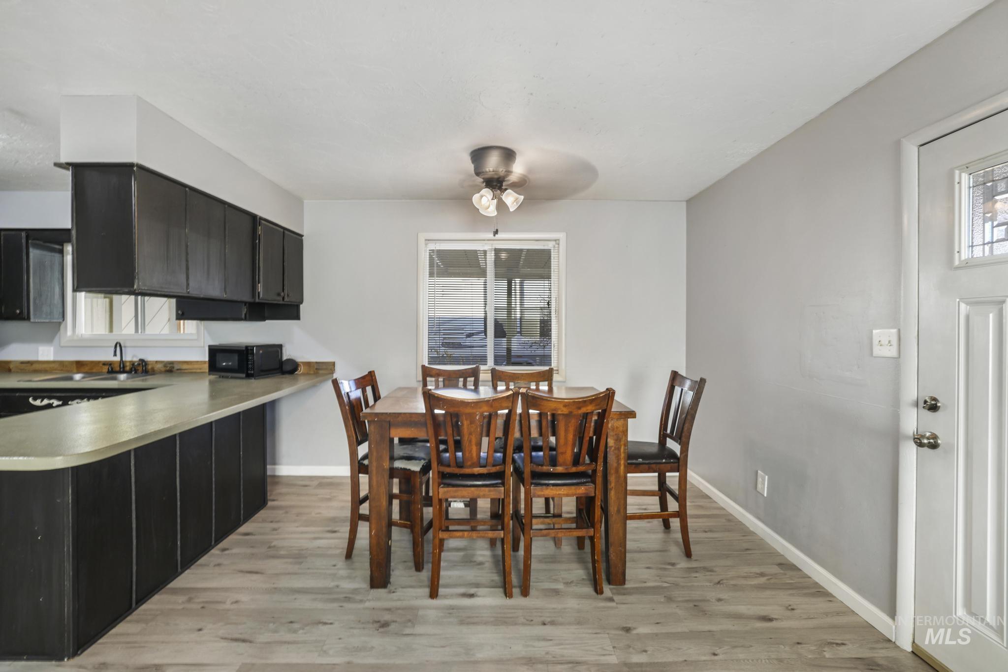 Dining space with light wood finished floors and ceiling fan