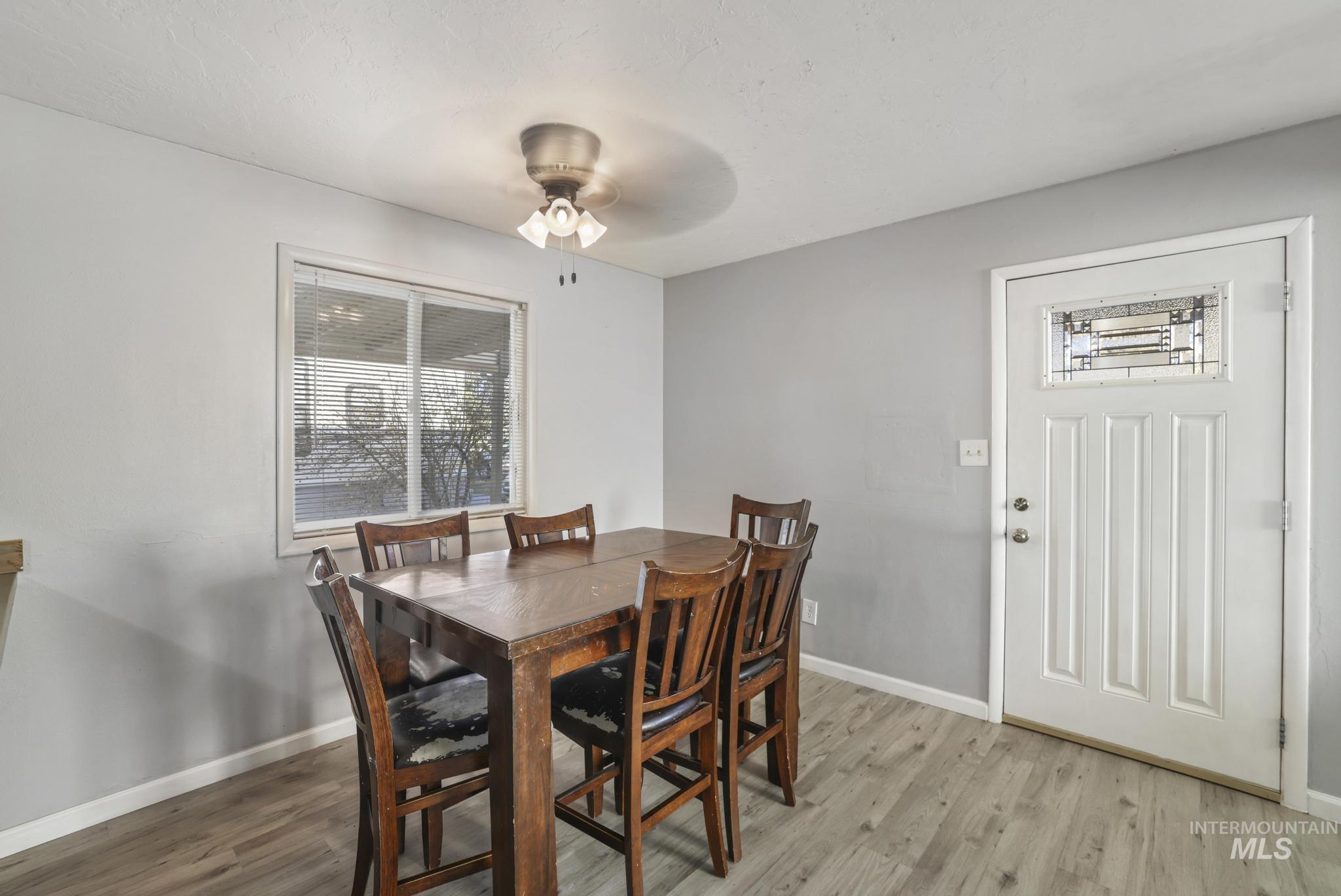 Dining space with wood finished floors and ceiling fan