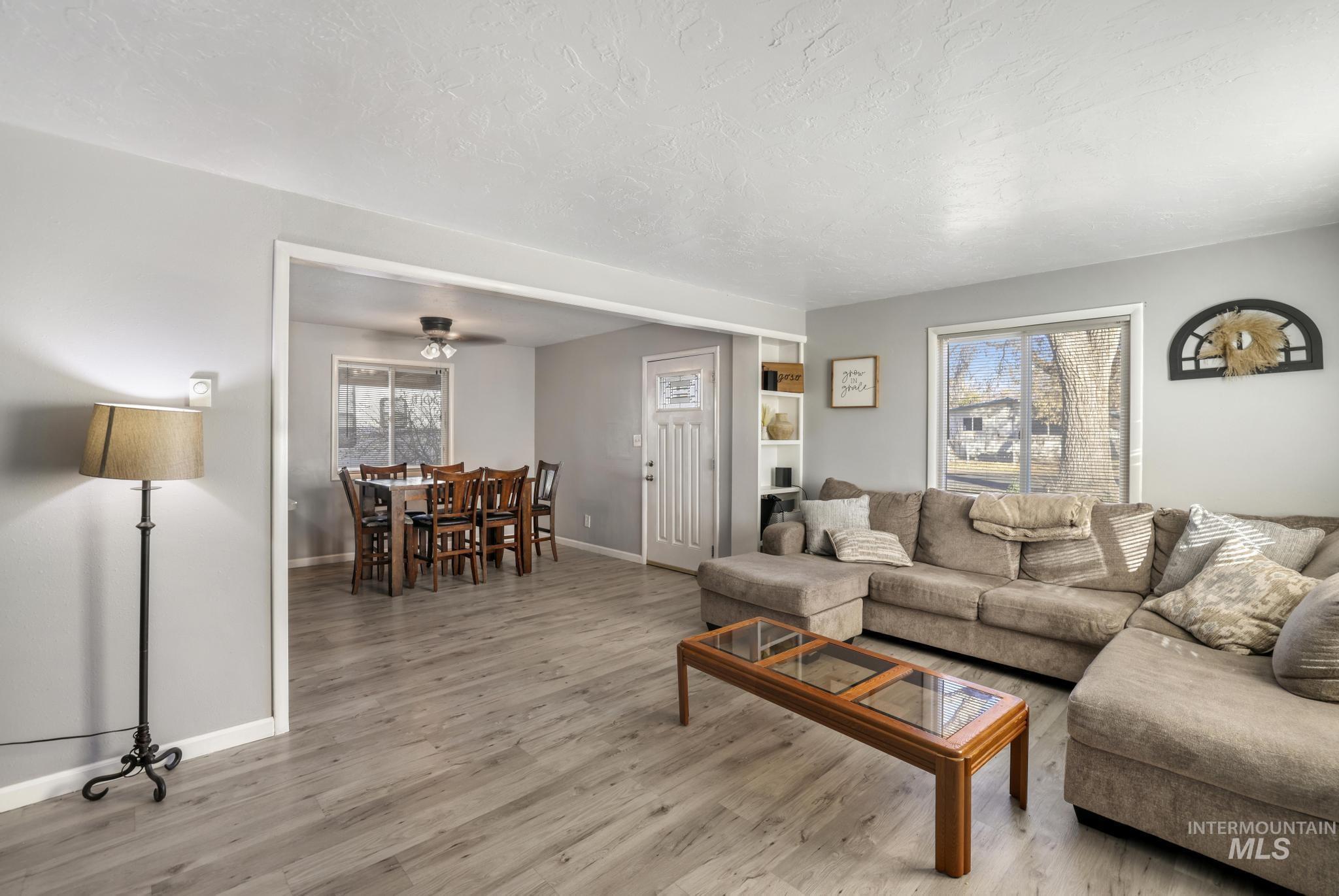 Living area with wood finished floors, ceiling fan, and a textured ceiling
