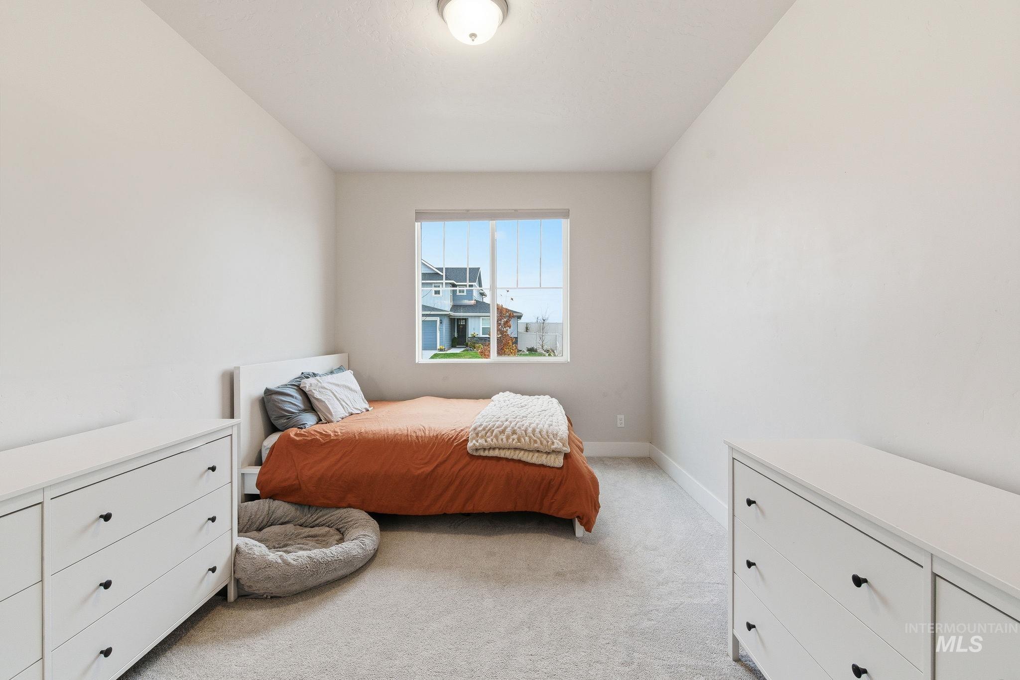Bedroom with light carpet and baseboards