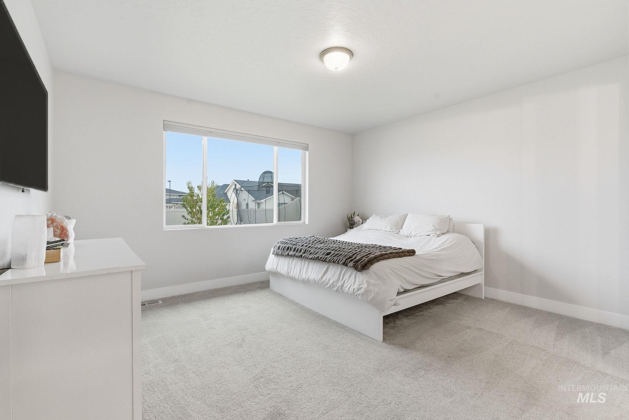 Bedroom with light carpet and baseboards