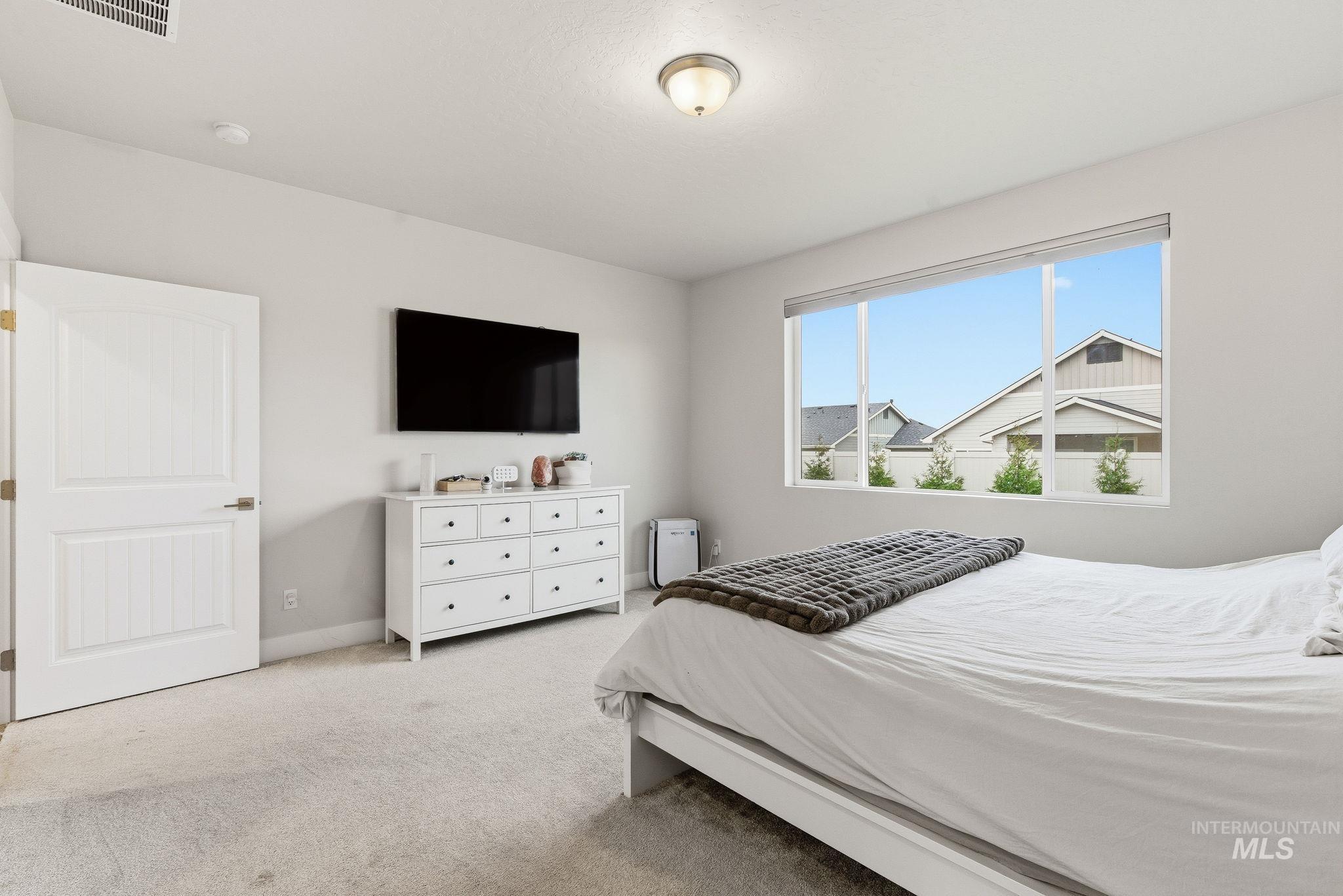 Bedroom featuring light colored carpet and baseboards