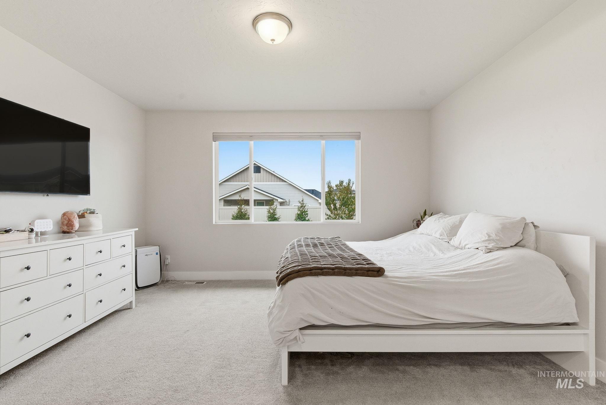 Bedroom with light carpet and baseboards