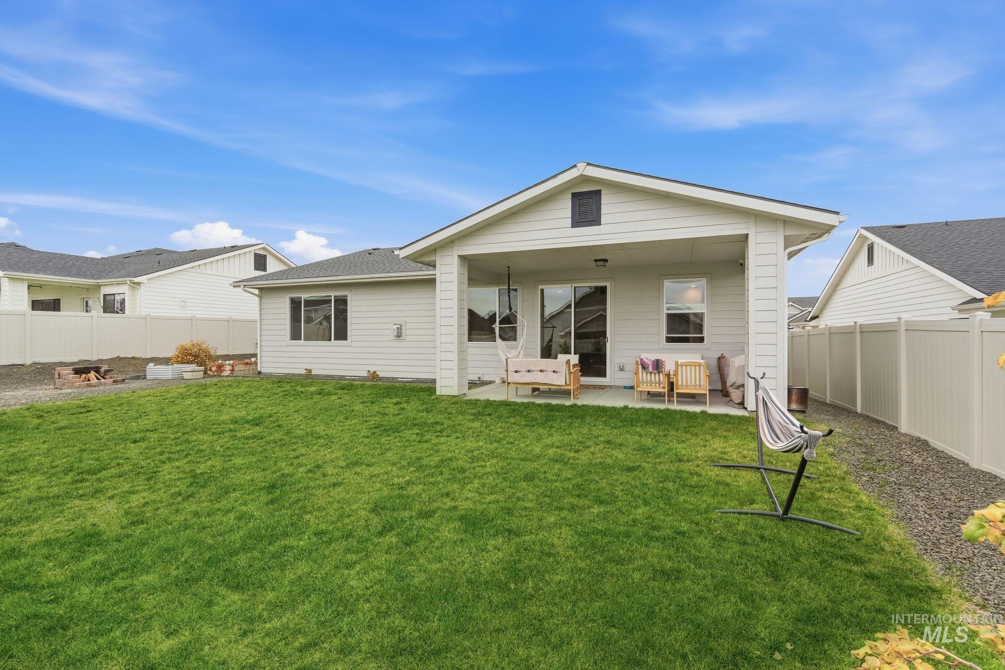 Back of property featuring a fenced backyard and a patio