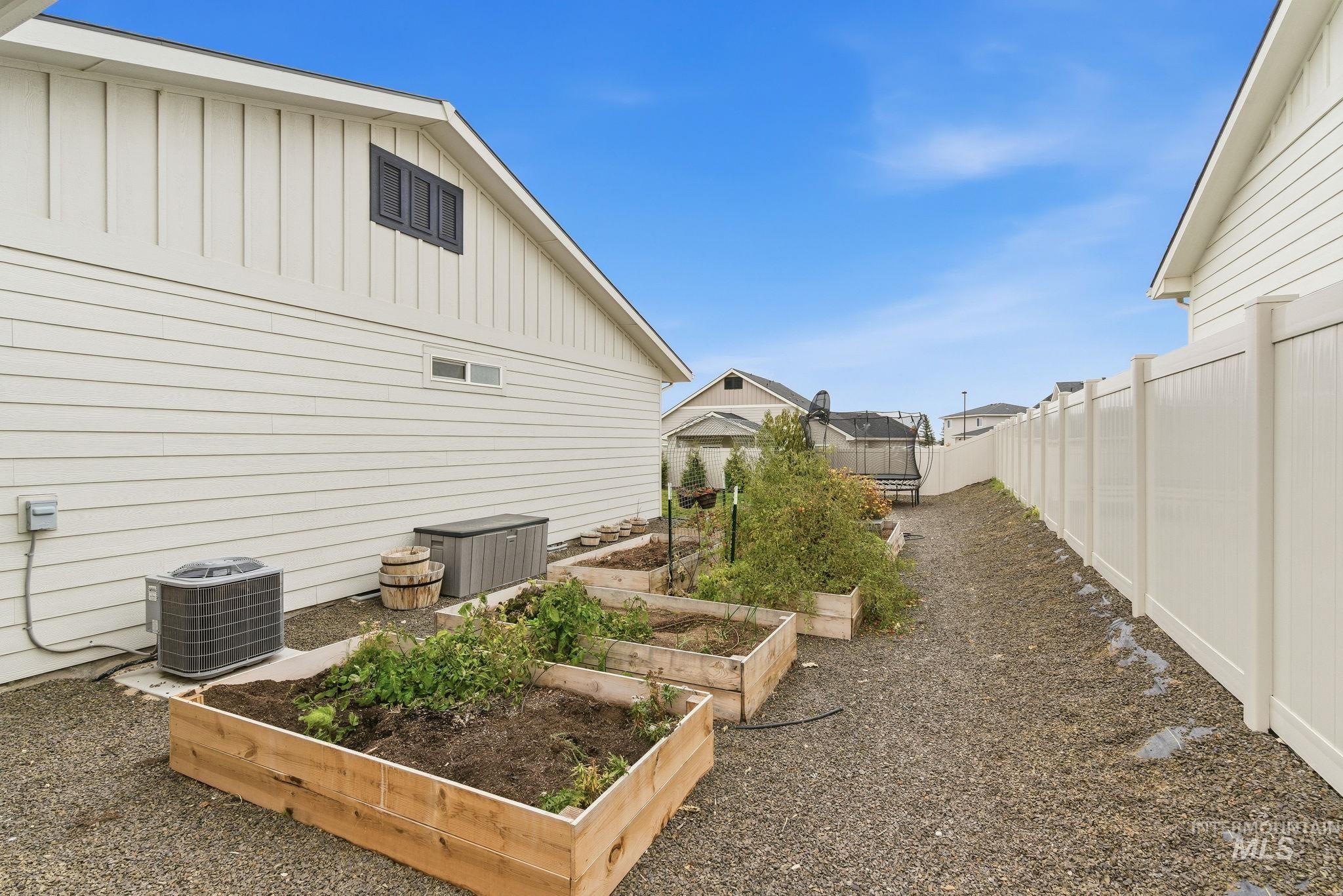 Fenced backyard featuring a vegetable garden