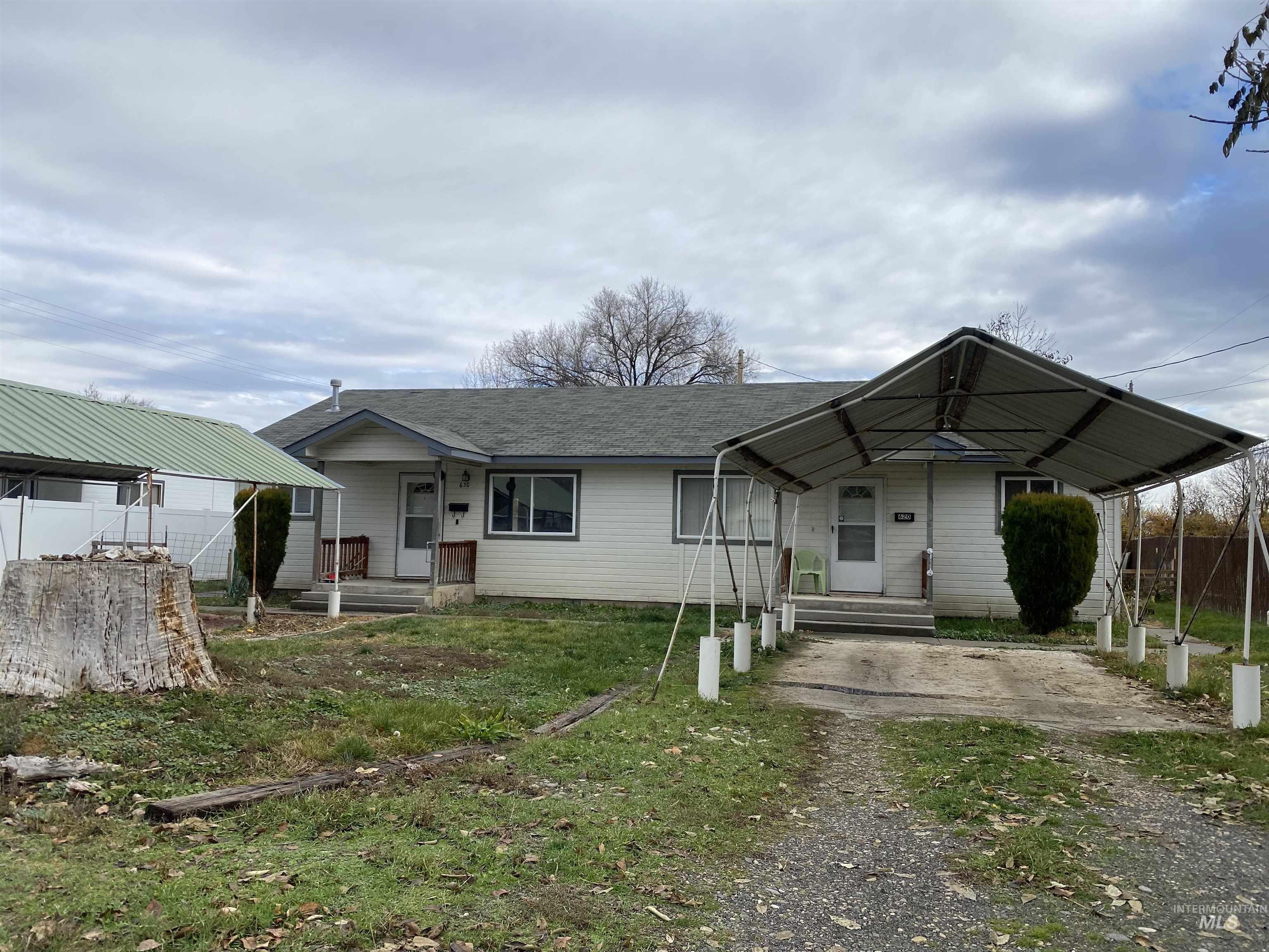 View of front of house with covered porch, a shingled roof, and a carport