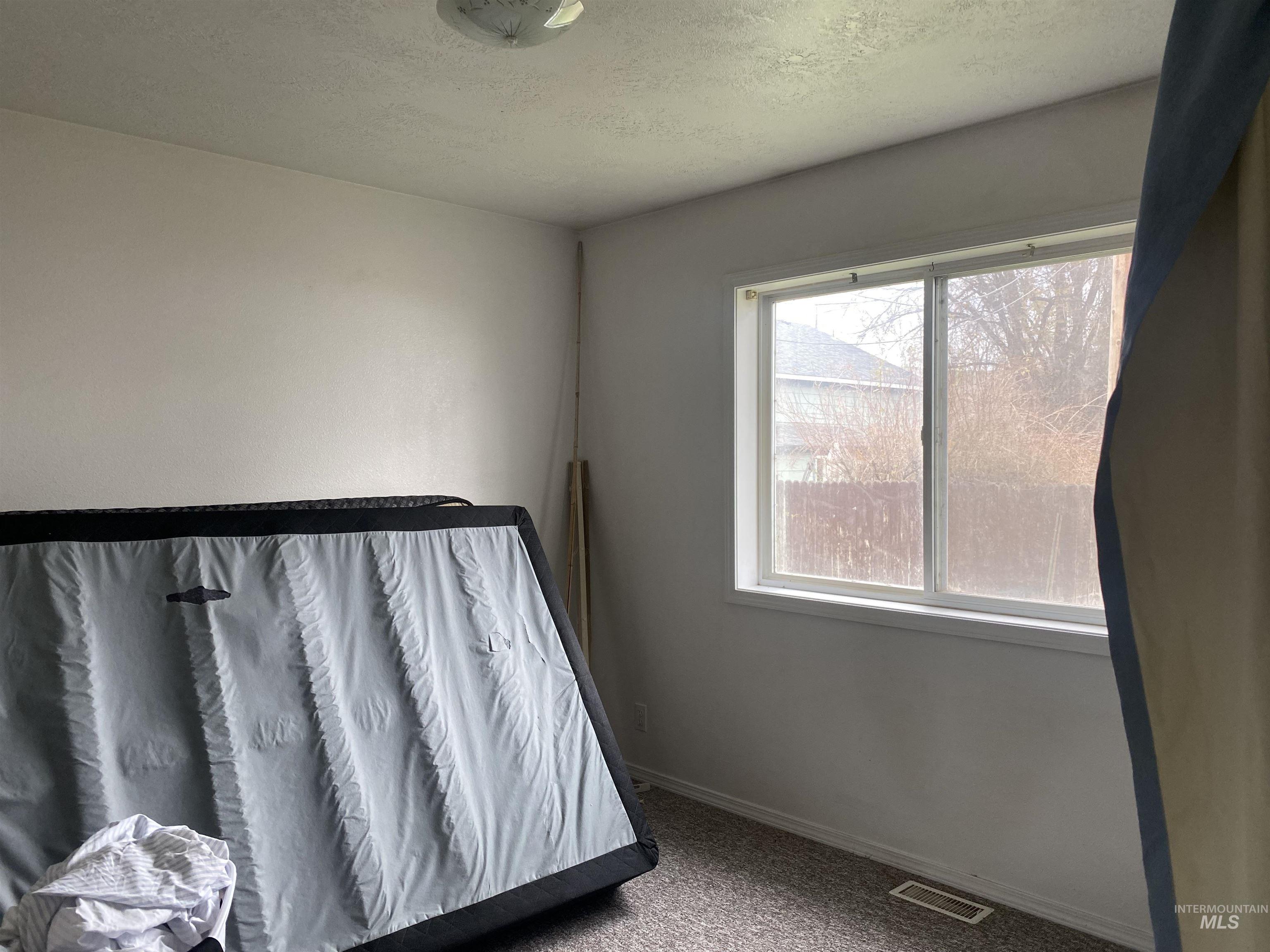 Bedroom featuring carpet and a textured ceiling