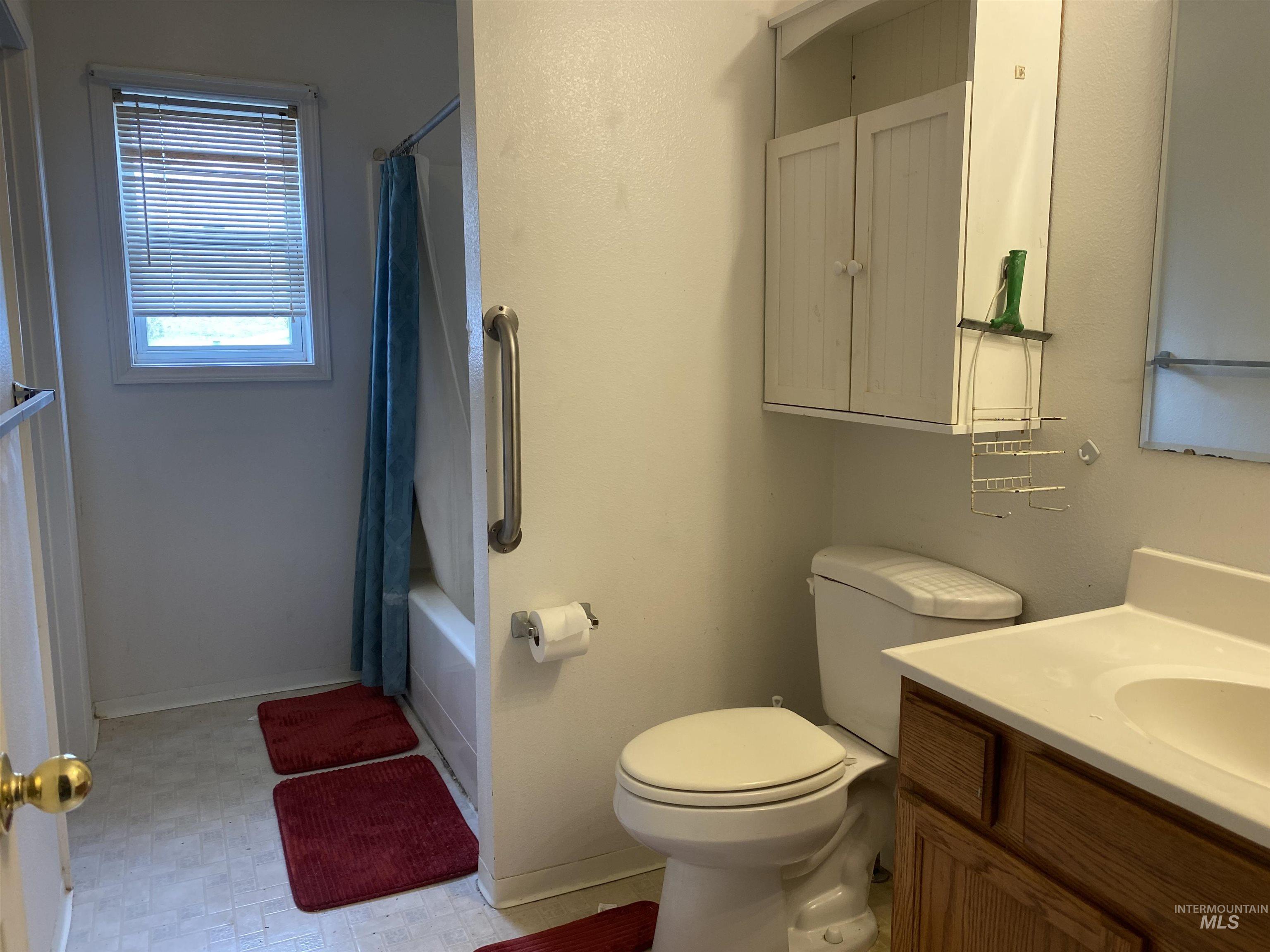 Bathroom featuring vanity and shower / tub combo with curtain