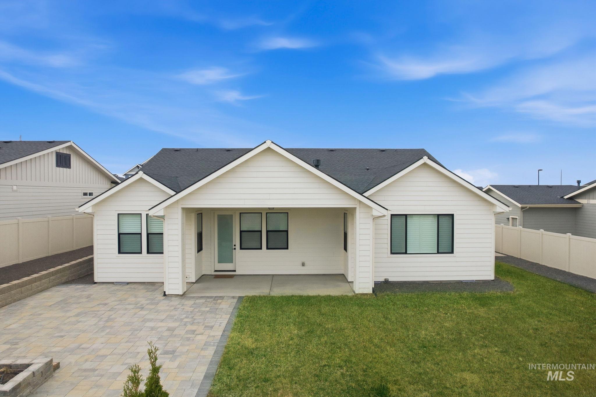 Rear view of house featuring a fenced backyard, a patio area, and a shingled roof