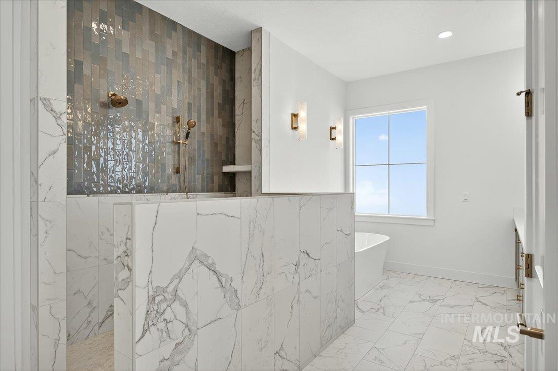 Bathroom featuring a marble finish shower, light marble finish flooring, a soaking tub, and vanity
