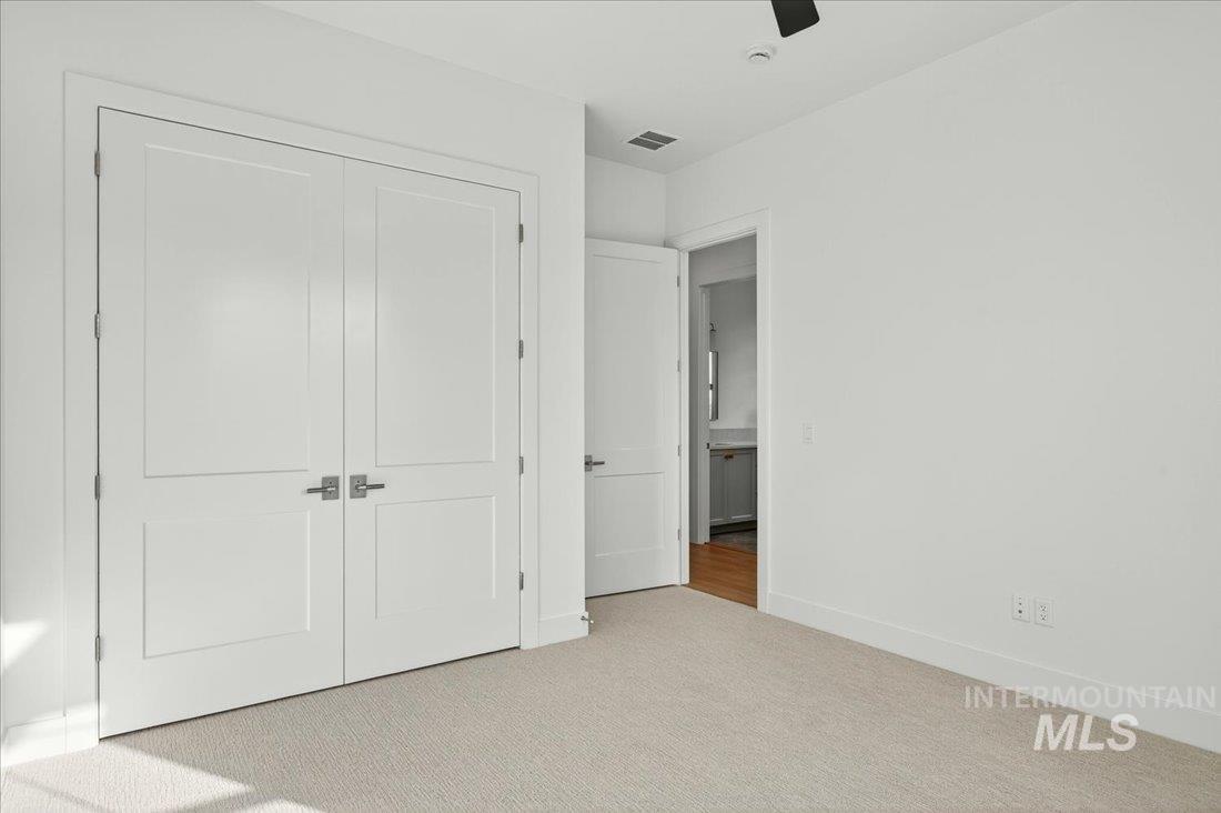Unfurnished bedroom featuring carpet floors, a closet, and ceiling fan