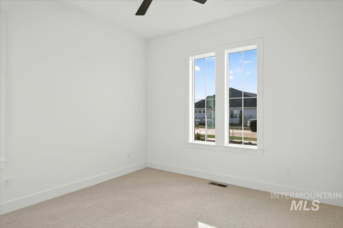 Unfurnished room featuring carpet flooring and a ceiling fan