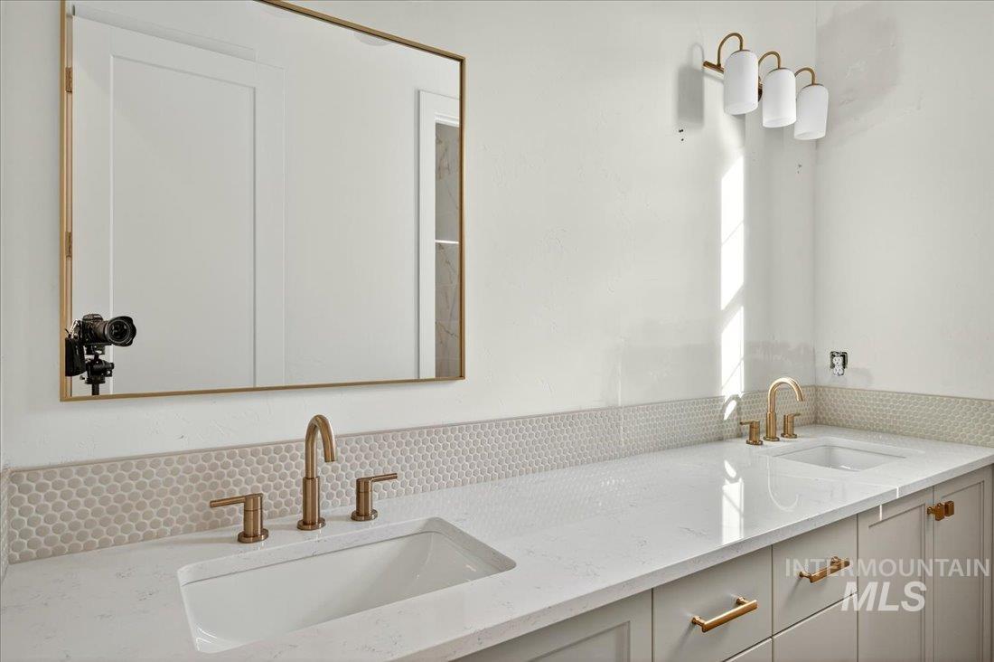 Bathroom featuring double vanity and decorative backsplash