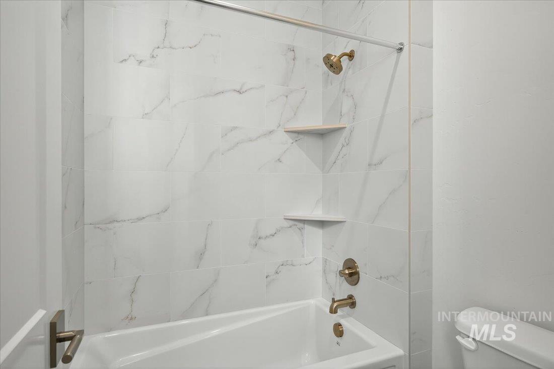 Full bath featuring bathtub / shower combination and toilet