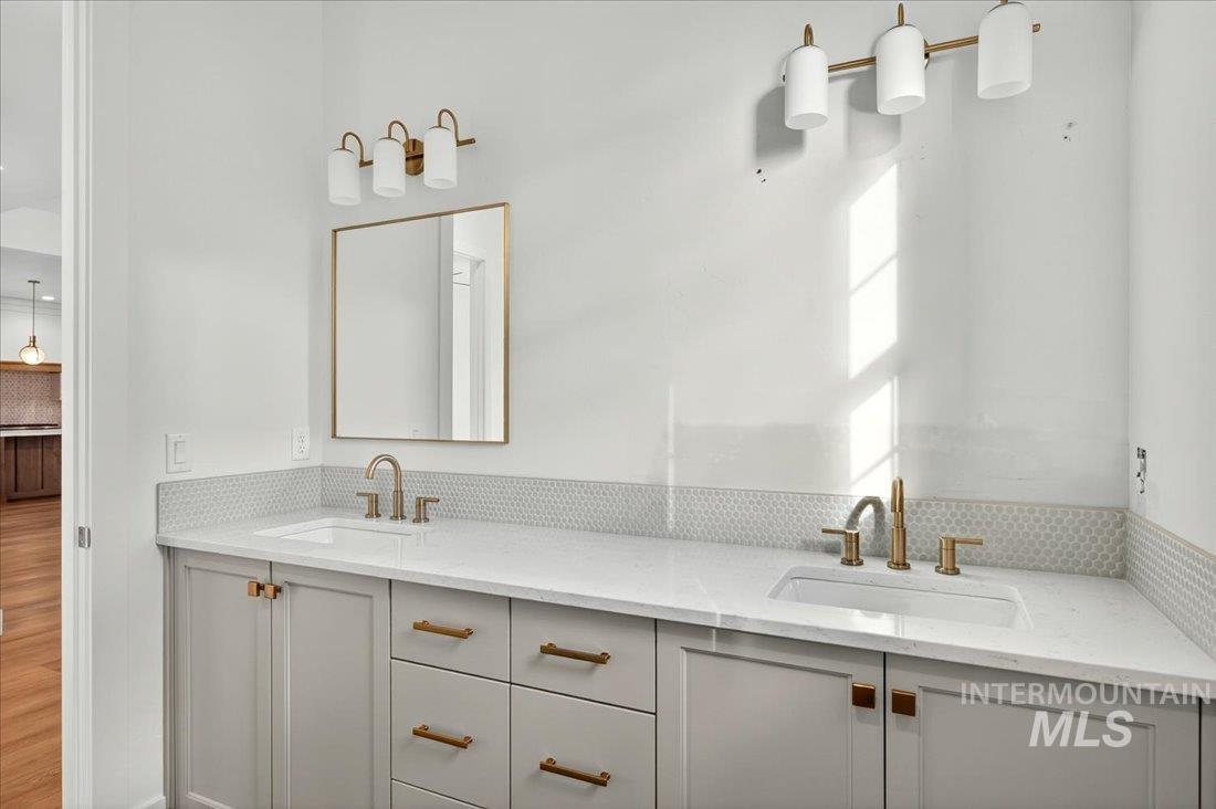 Bathroom with double vanity and tasteful backsplash