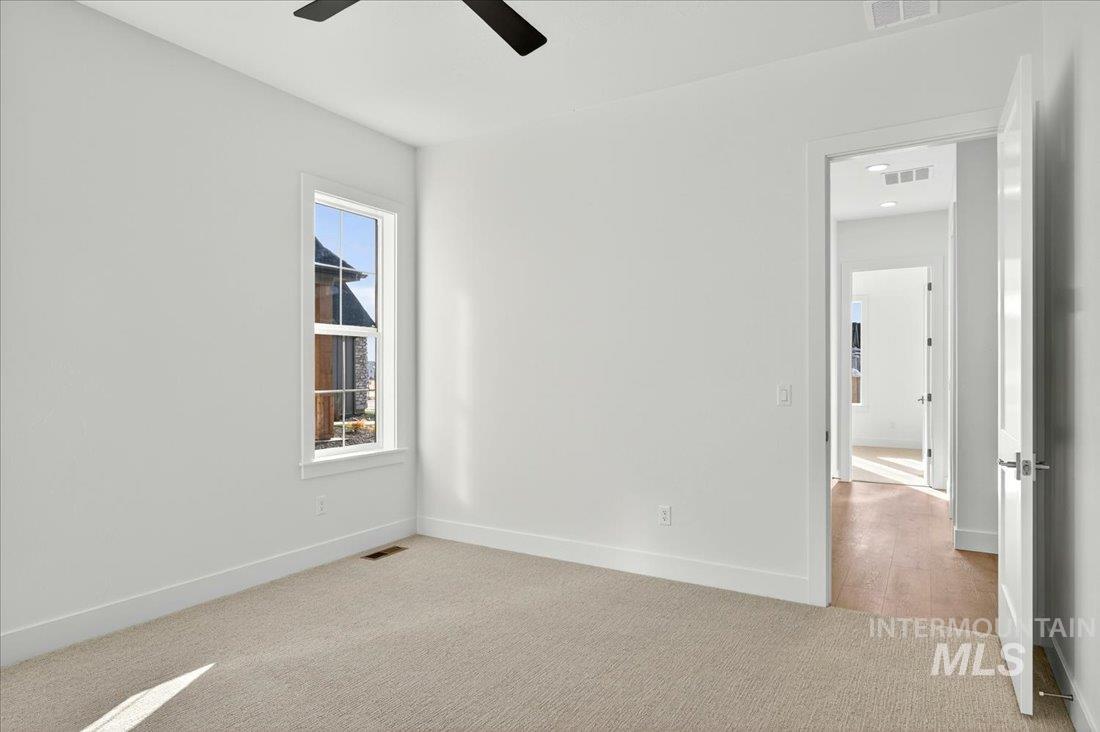 Spare room with carpet floors and a ceiling fan