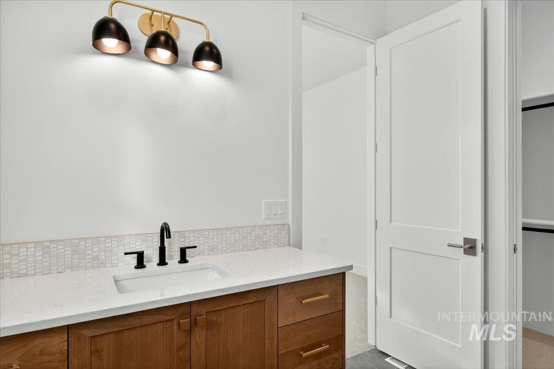 Bathroom with vanity and backsplash